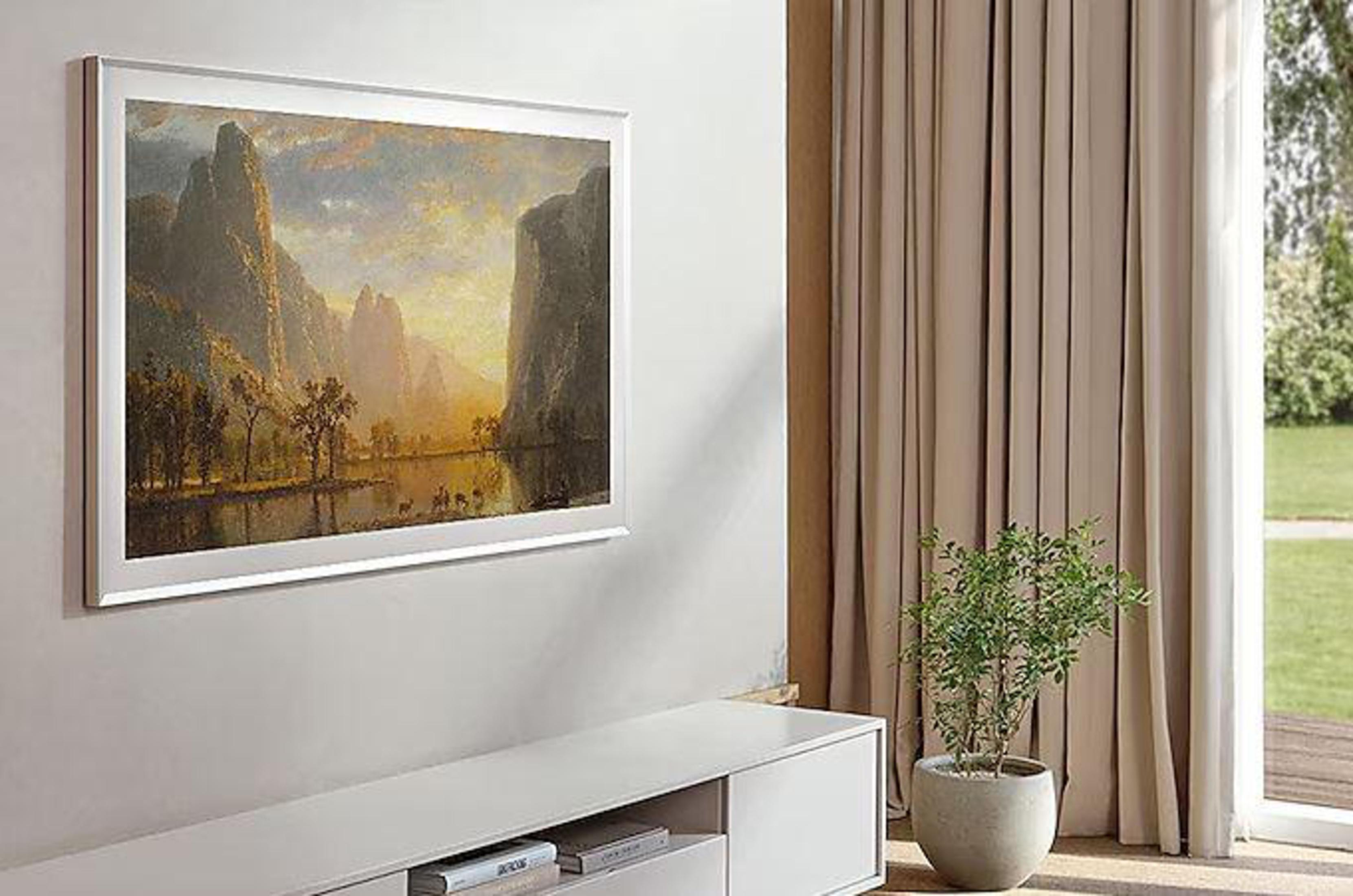 Obraz w ramie na ścianie, z białą szafką i rośliną w pobliżu. Zasłony po prawej.