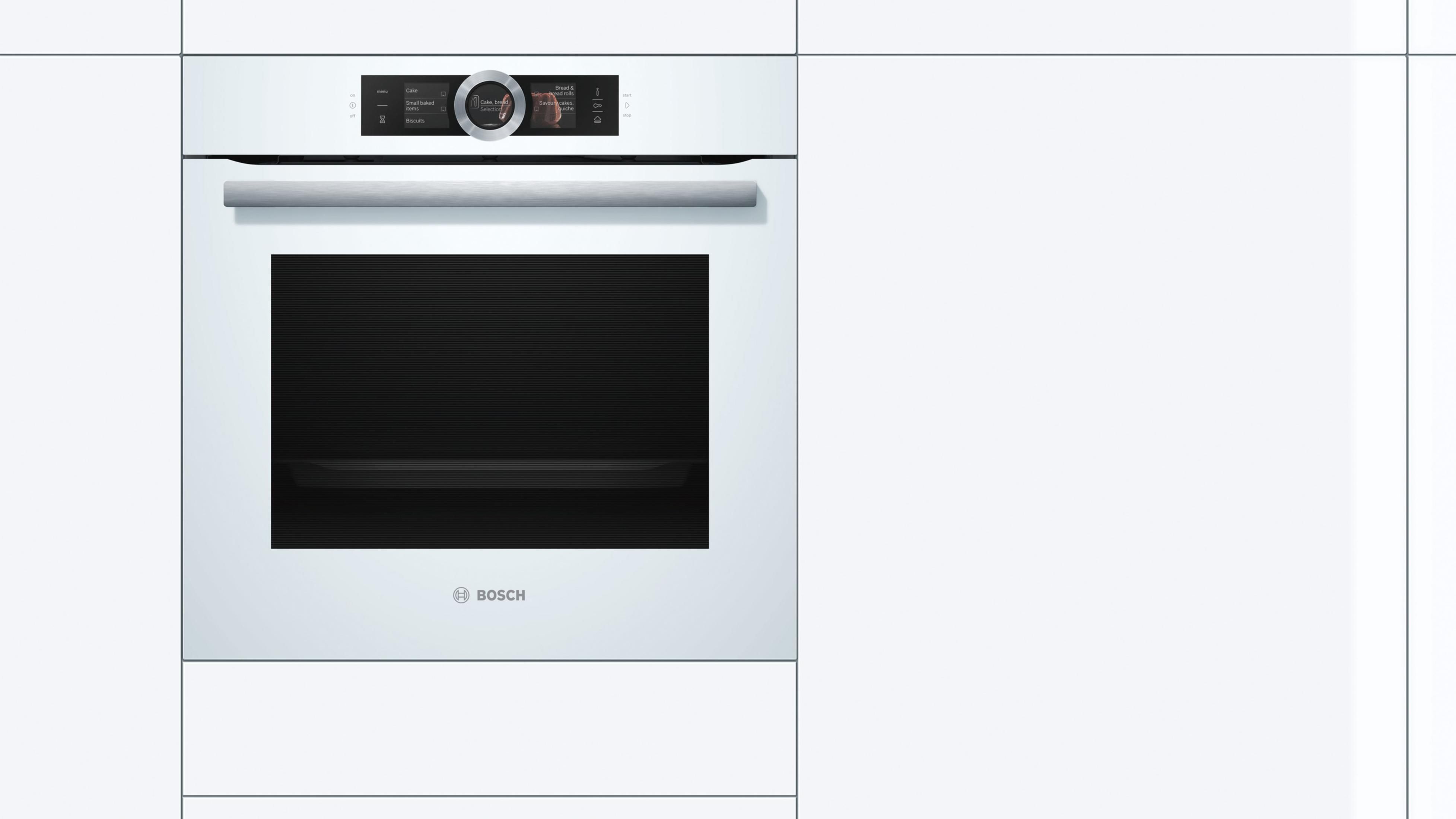 Un horno empotrado blanco con pantalla digital en un entorno de cocina blanco.