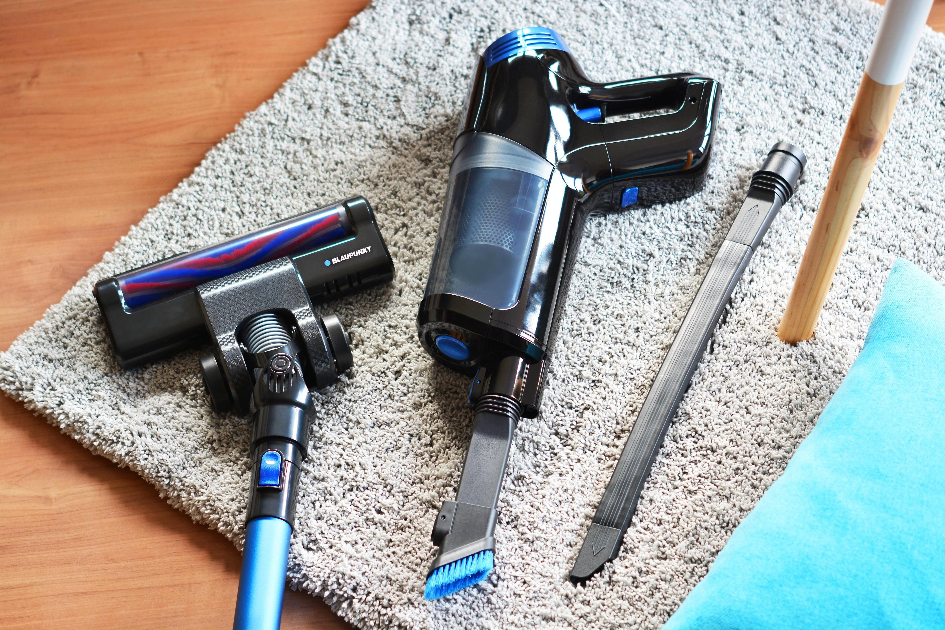 Bezprzewodowy odkurzacz z niebieskimi i czarnymi elementami oraz różnymi końcówkami.