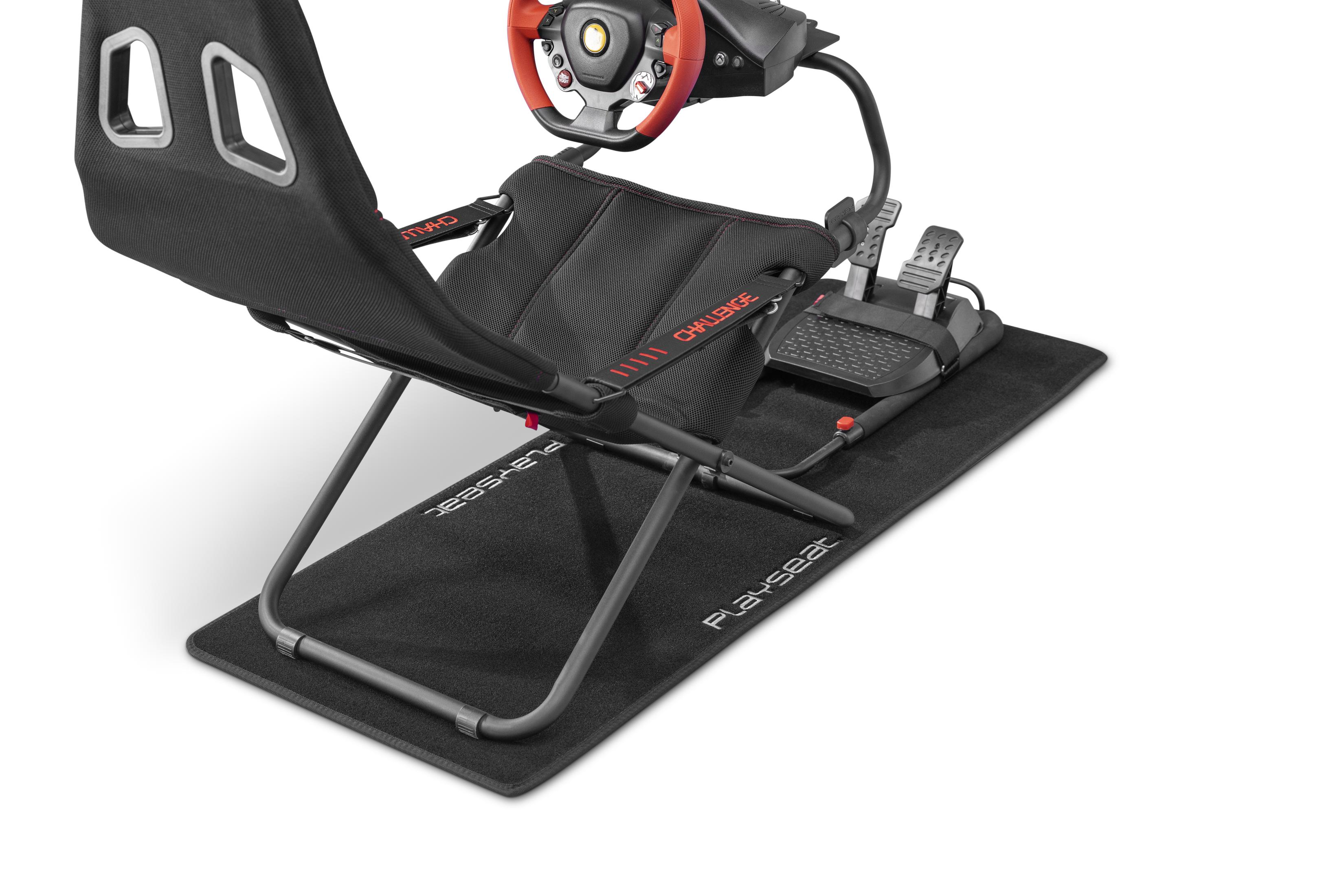 Una sedia da corsa e pedali su un tappetino nero, con volante rosso e nero.