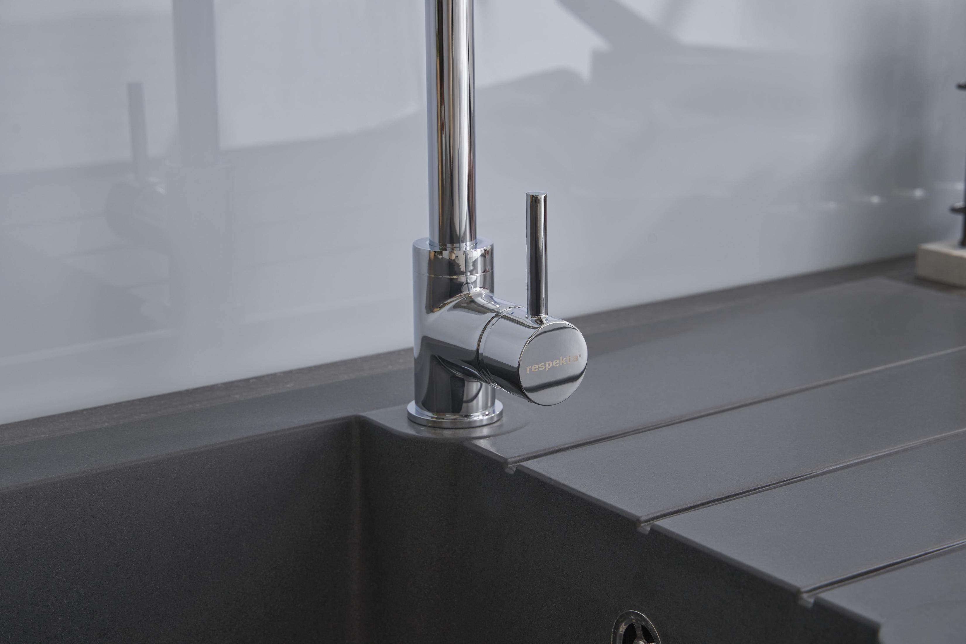 Nahaufnahme eines Chrom-Wasserhahns in einer modernen Küche. Graues Waschbecken und weißer Spiegel.