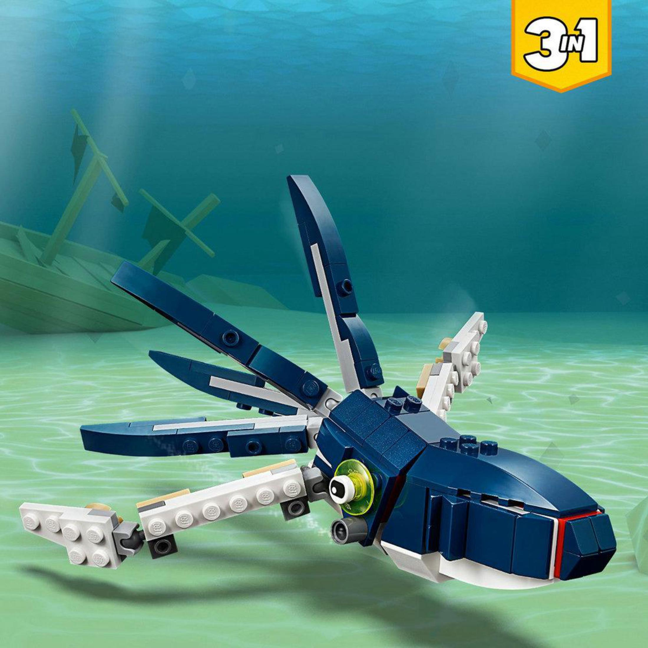 Zabawka Lego przedstawiająca niebieskie stworzenie podobne do rekina z wrakiem statku w tle.