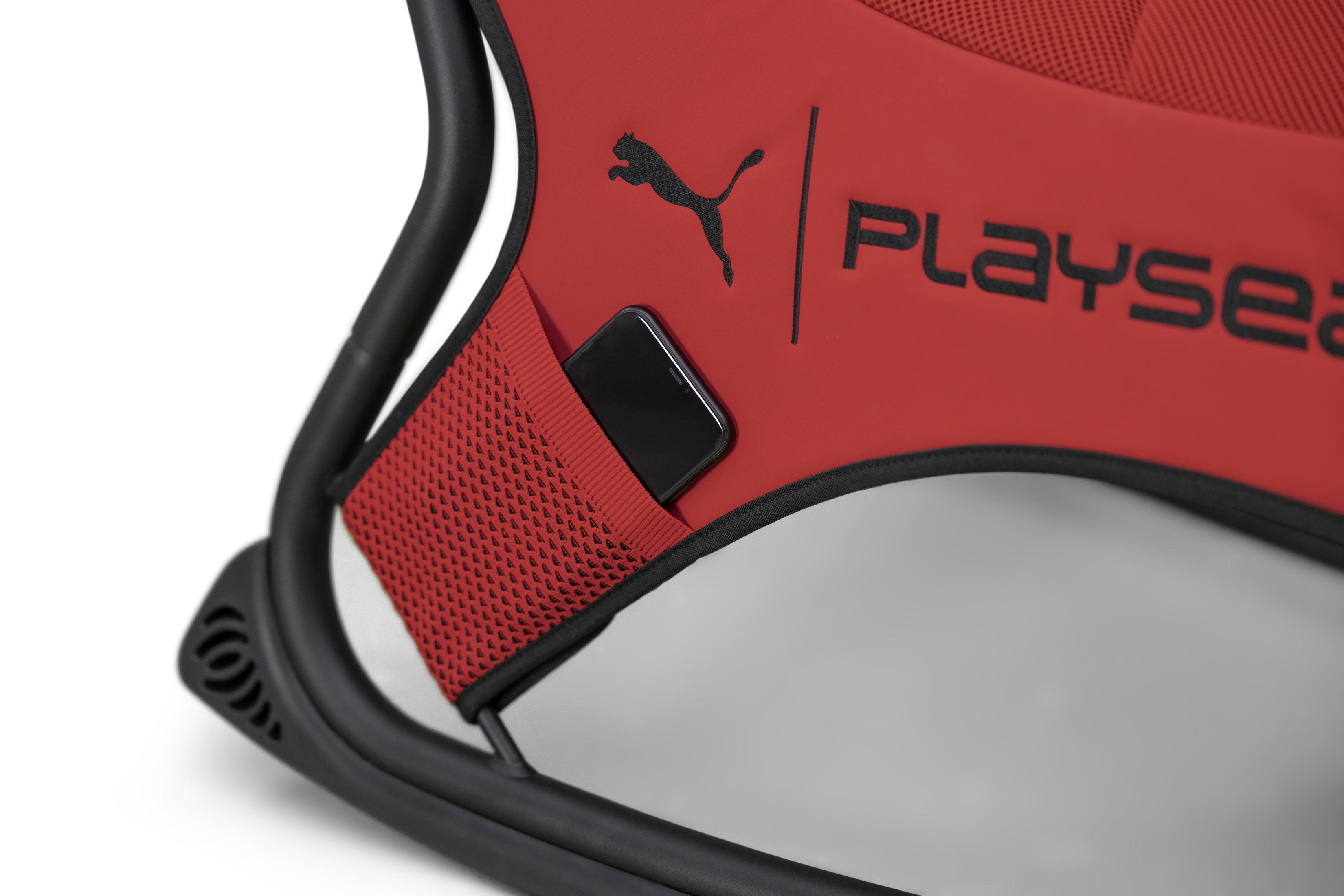Een rode gamingstoel met een telefoon in een zak. Het logo is "Puma" en "Playseat".