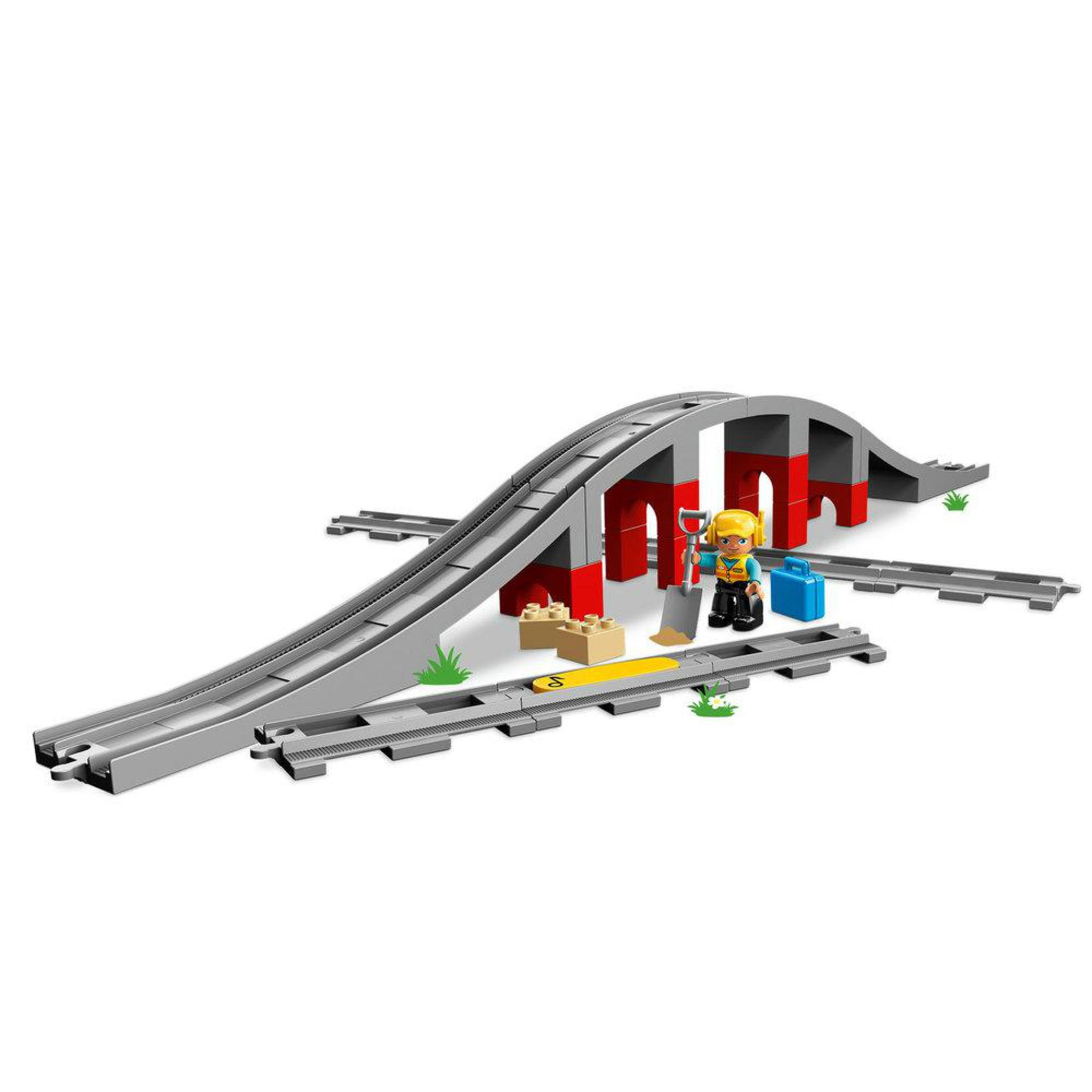Un set Lego Duplo con binari, un ponte, una figura e strumenti di costruzione.