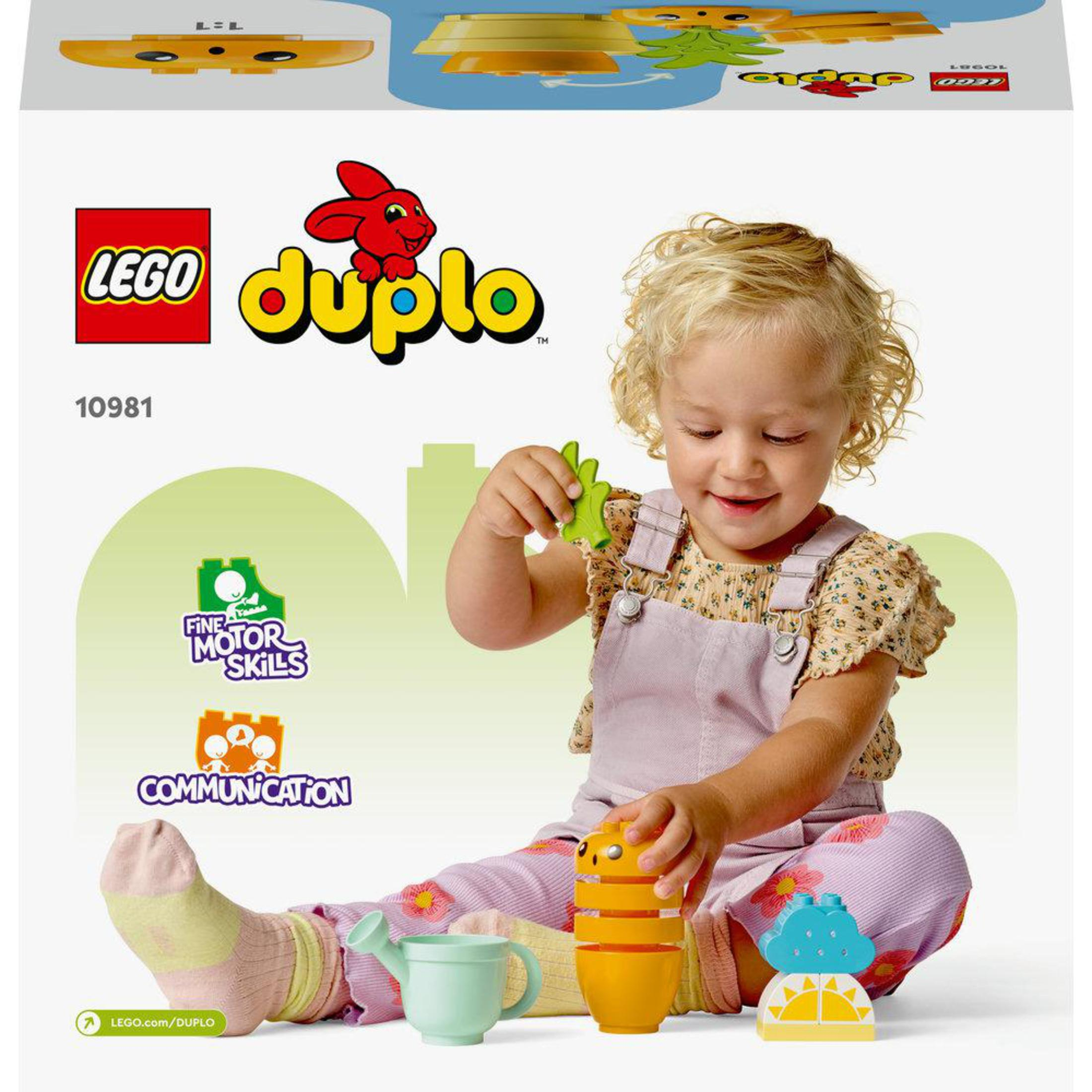 Een kind speelt met Duplo blokken. Er zijn speelgoedfiguren en een gieter in de scène.