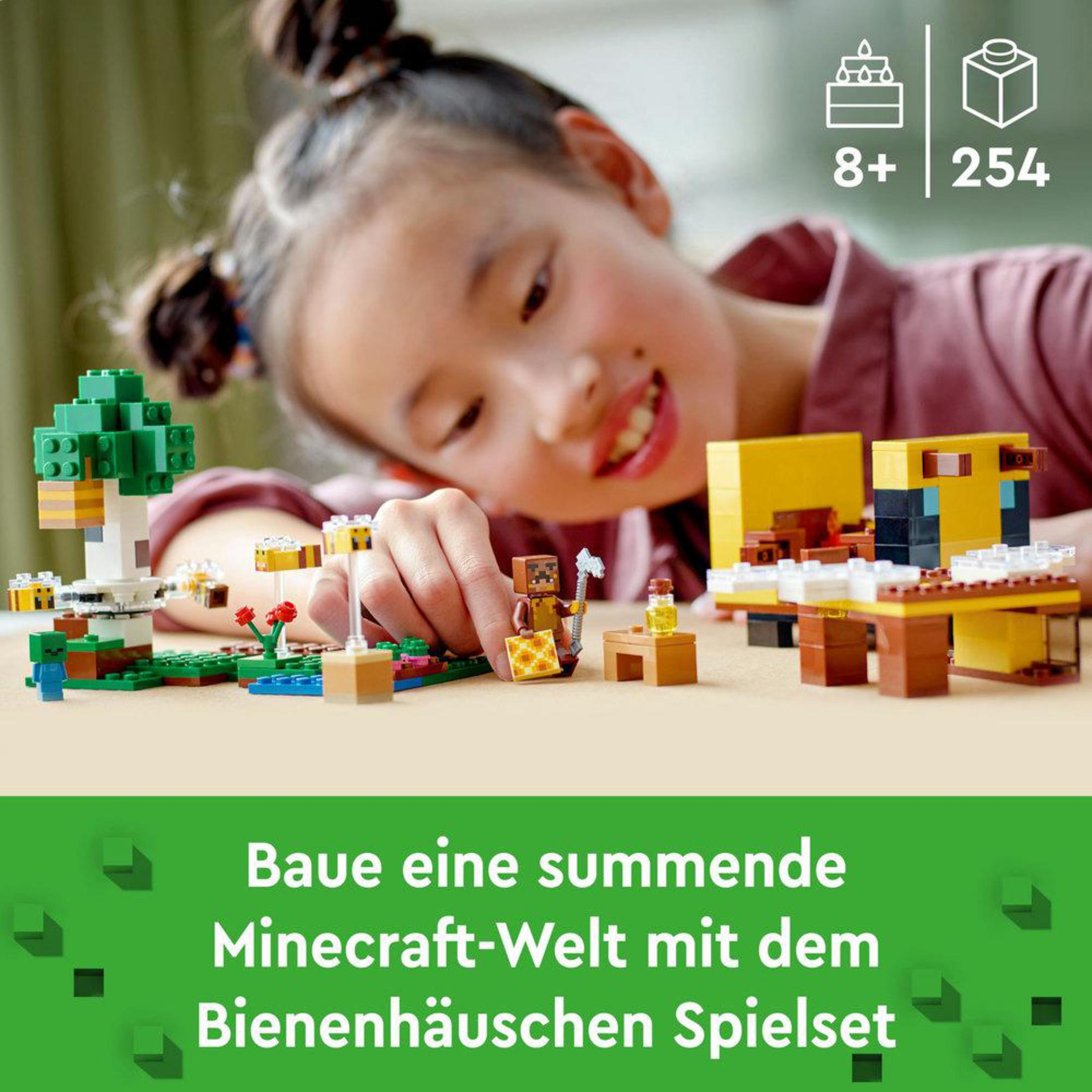Une fille joue avec un set Lego Minecraft. Avec une maison d'abeilles et des figurines.