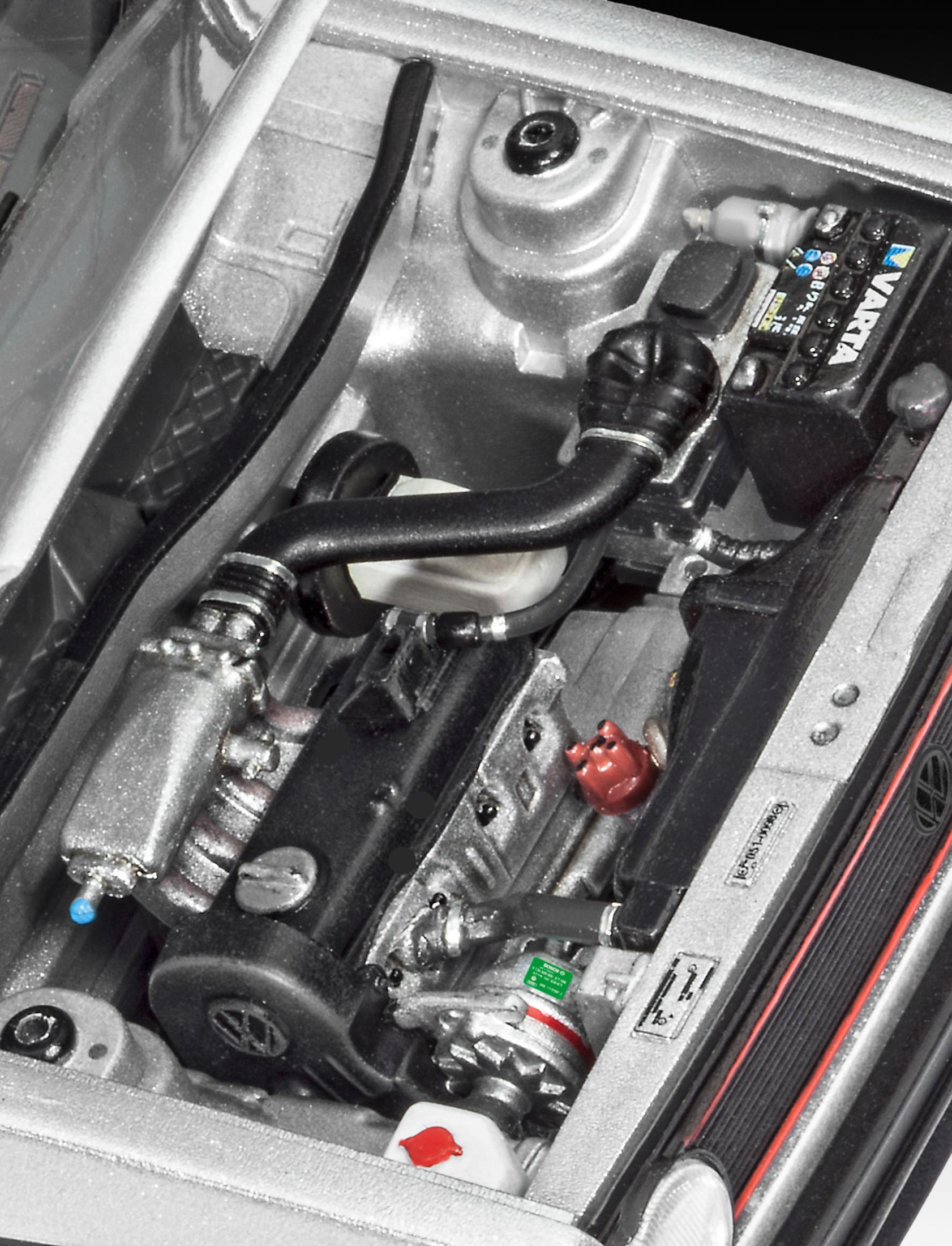 Model silnika samochodowego. Widoczne czarne elementy, rury i czerwone detale.