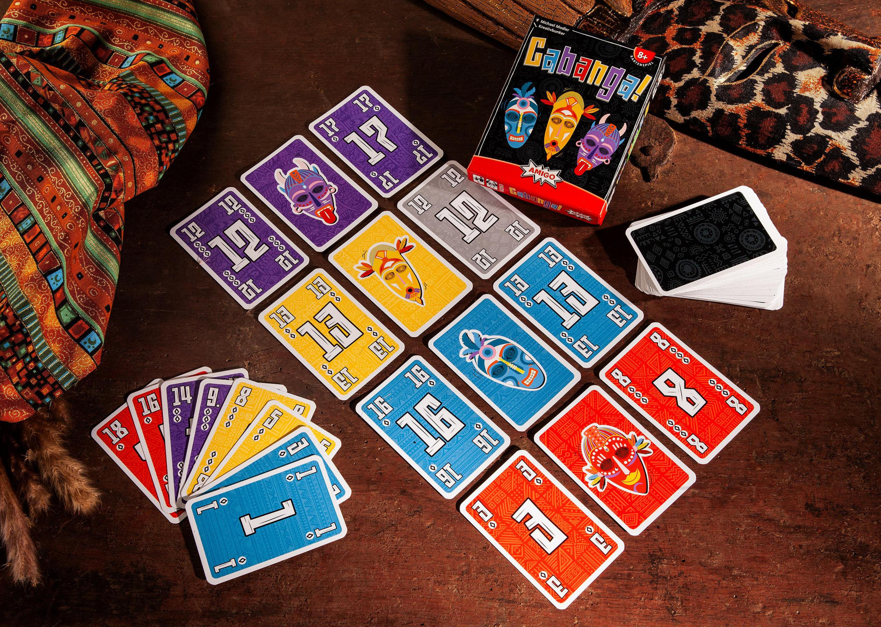 Un jeu avec des cartes. Les cartes montrent des masques. Les cartes sont étalées sur une surface en bois.