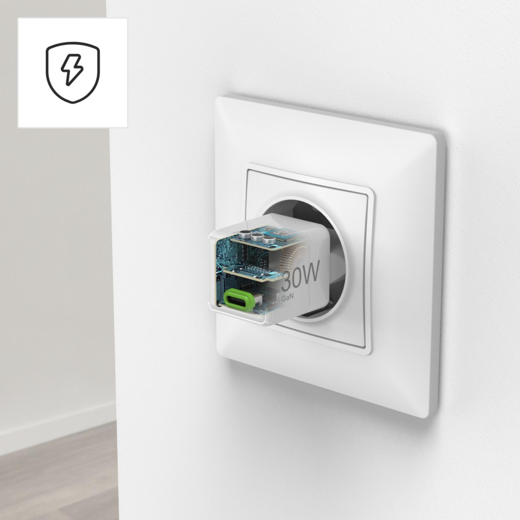 Adaptador de corriente blanco enchufado en un enchufe de pared blanco. Corte muestra componentes internos.
