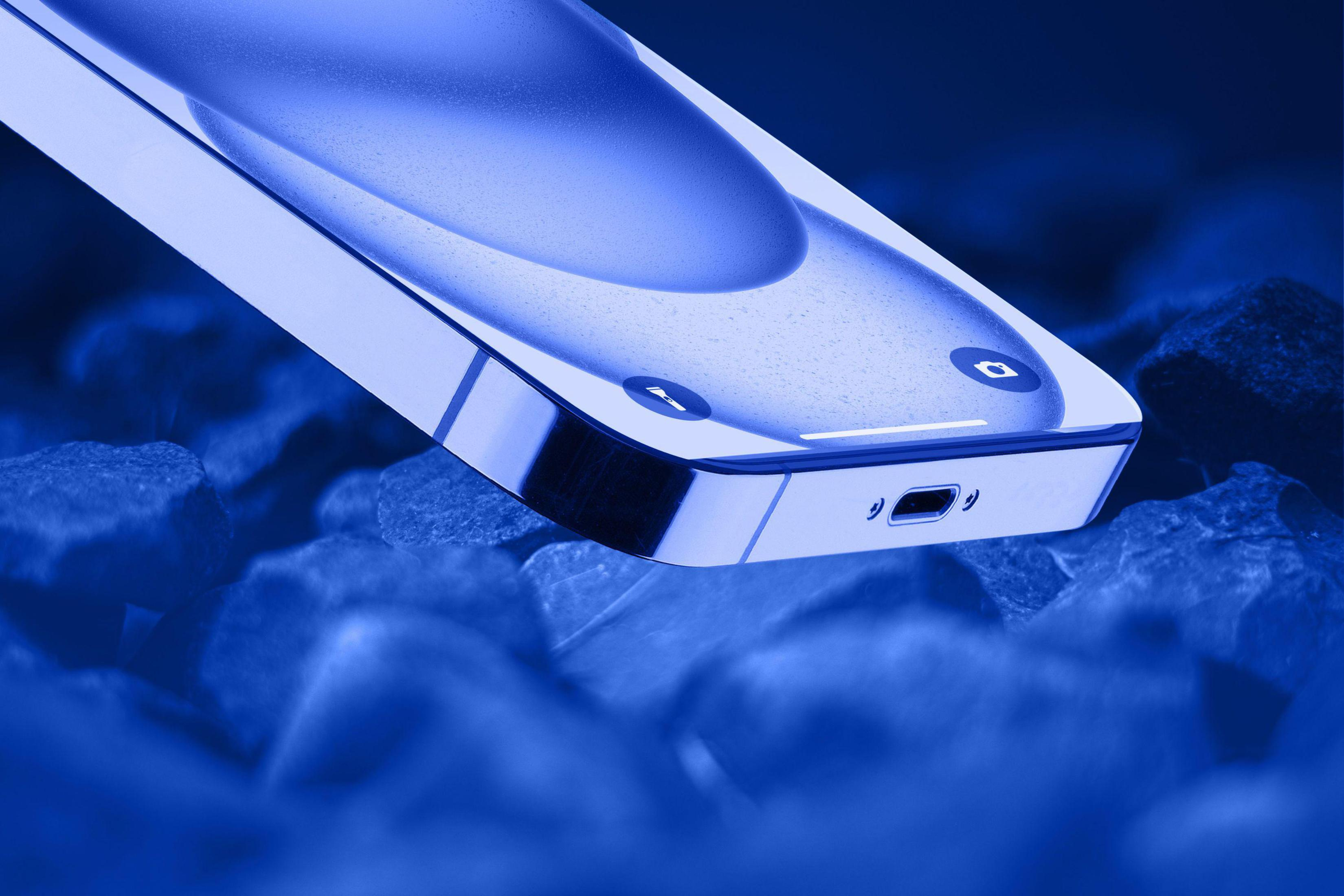 Smartphone con tinte azul, sobre rocas azuladas. La pantalla muestra una pantalla de inicio.