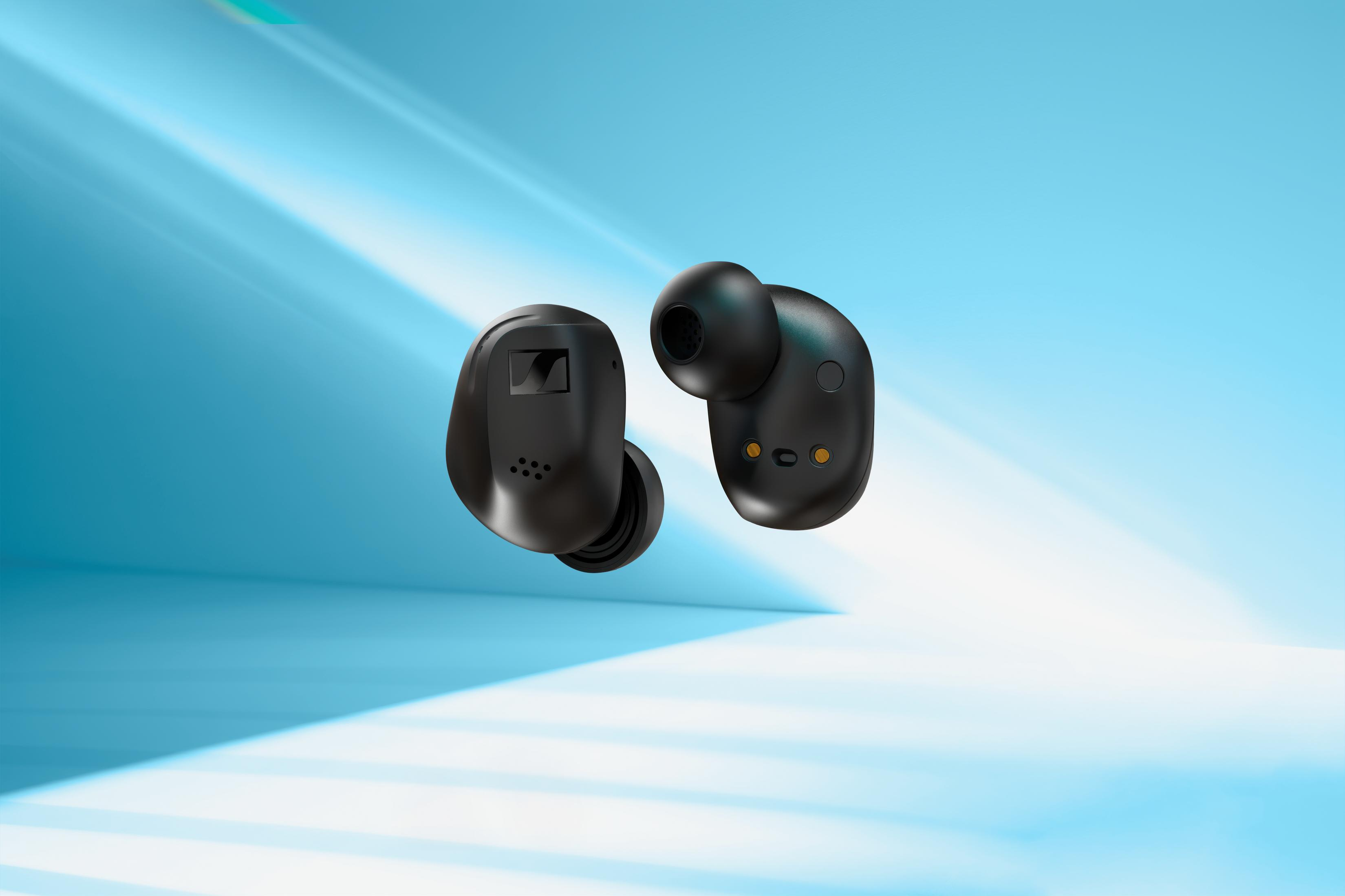 Dos auriculares inalámbricos negros flotando en el aire sobre un fondo azul con luz.