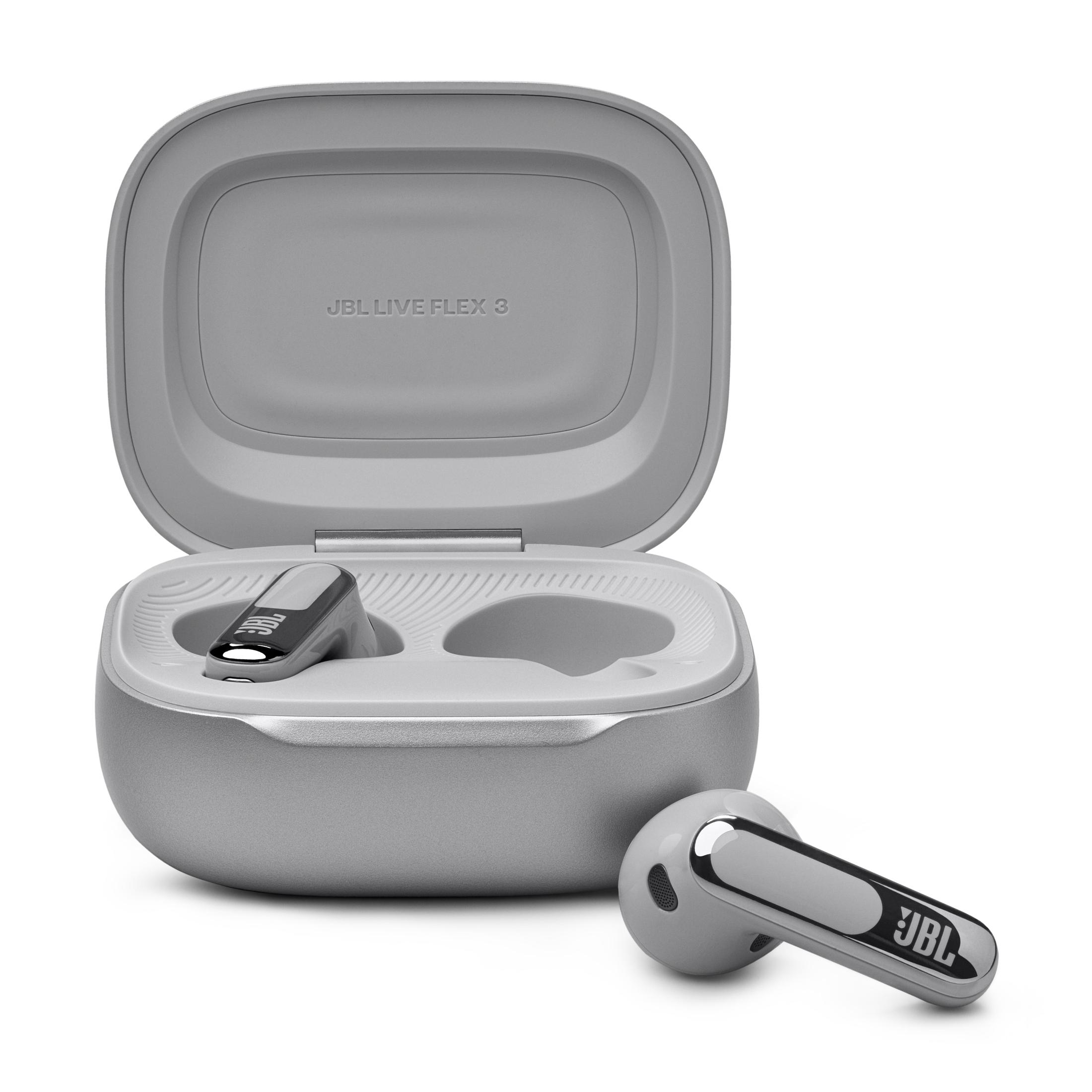 Auricolari JBL grigi in una custodia di ricarica grigia, su una superficie bianca. Un auricolare è fuori dalla custodia.