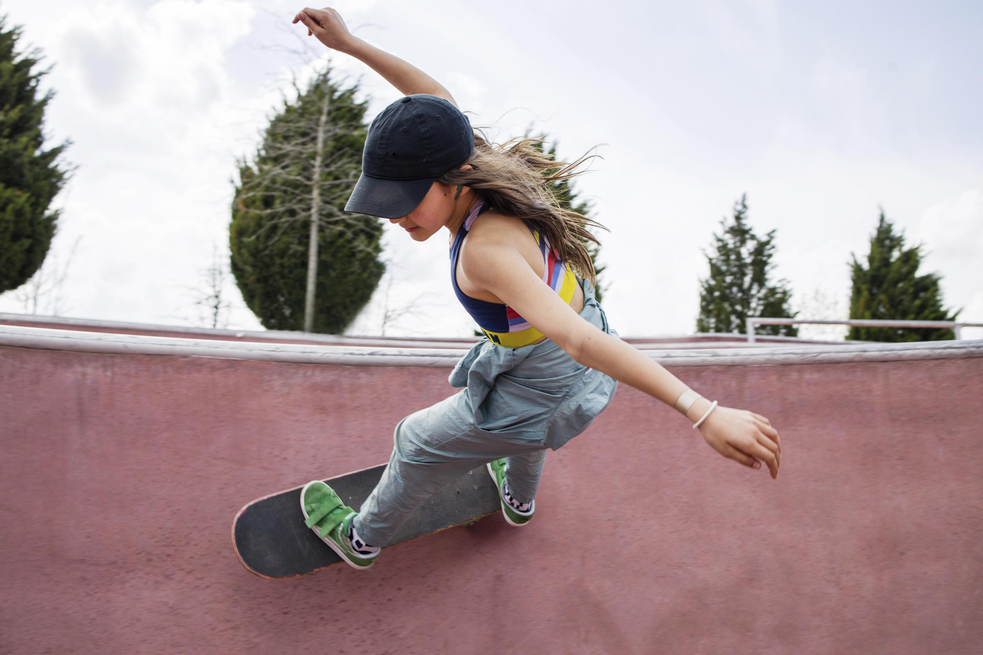Jonge persoon die skateboard in een skatepark, een truc uitvoert.