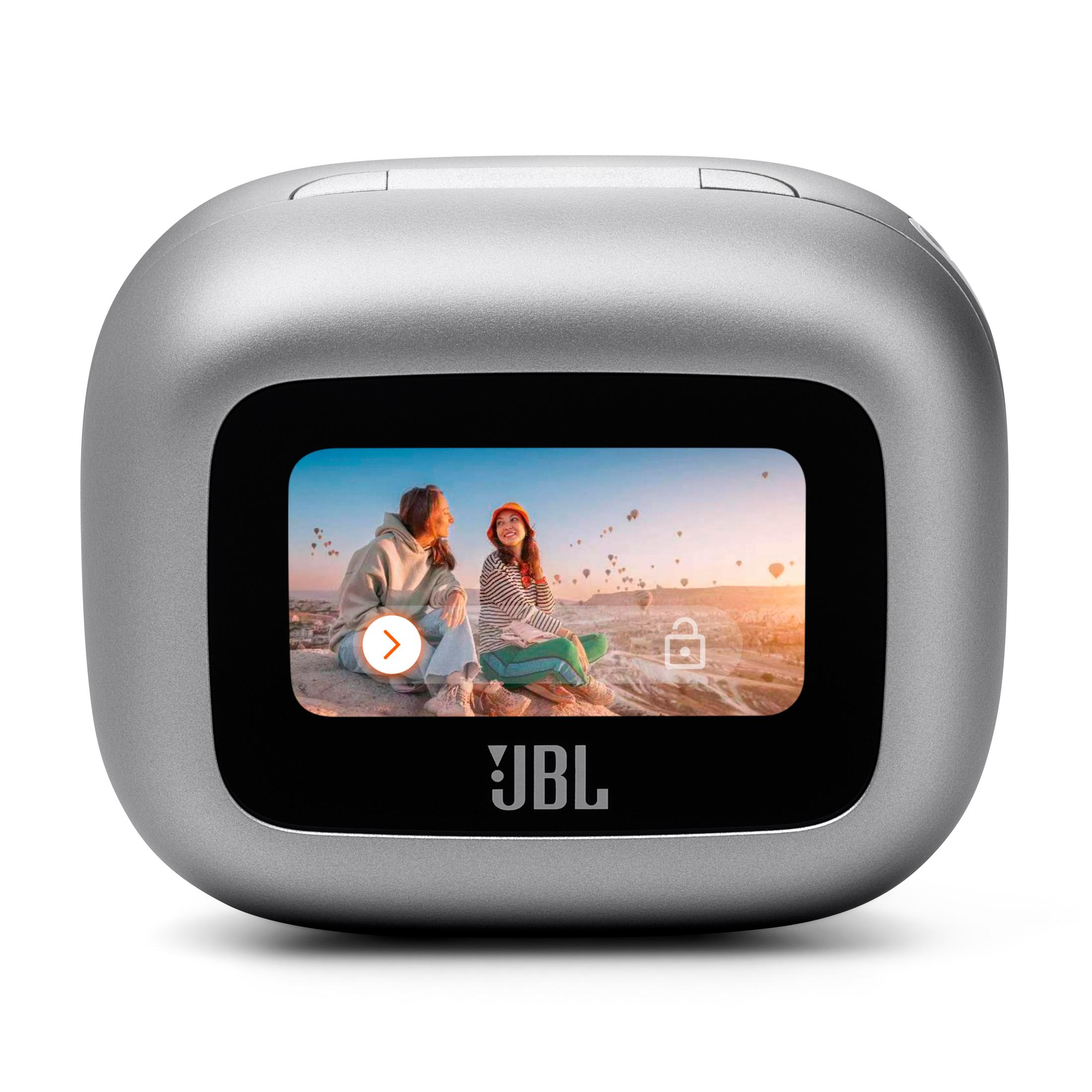 Fotocamera JBL argentata con uno schermo che mostra due persone sedute e palloncini.