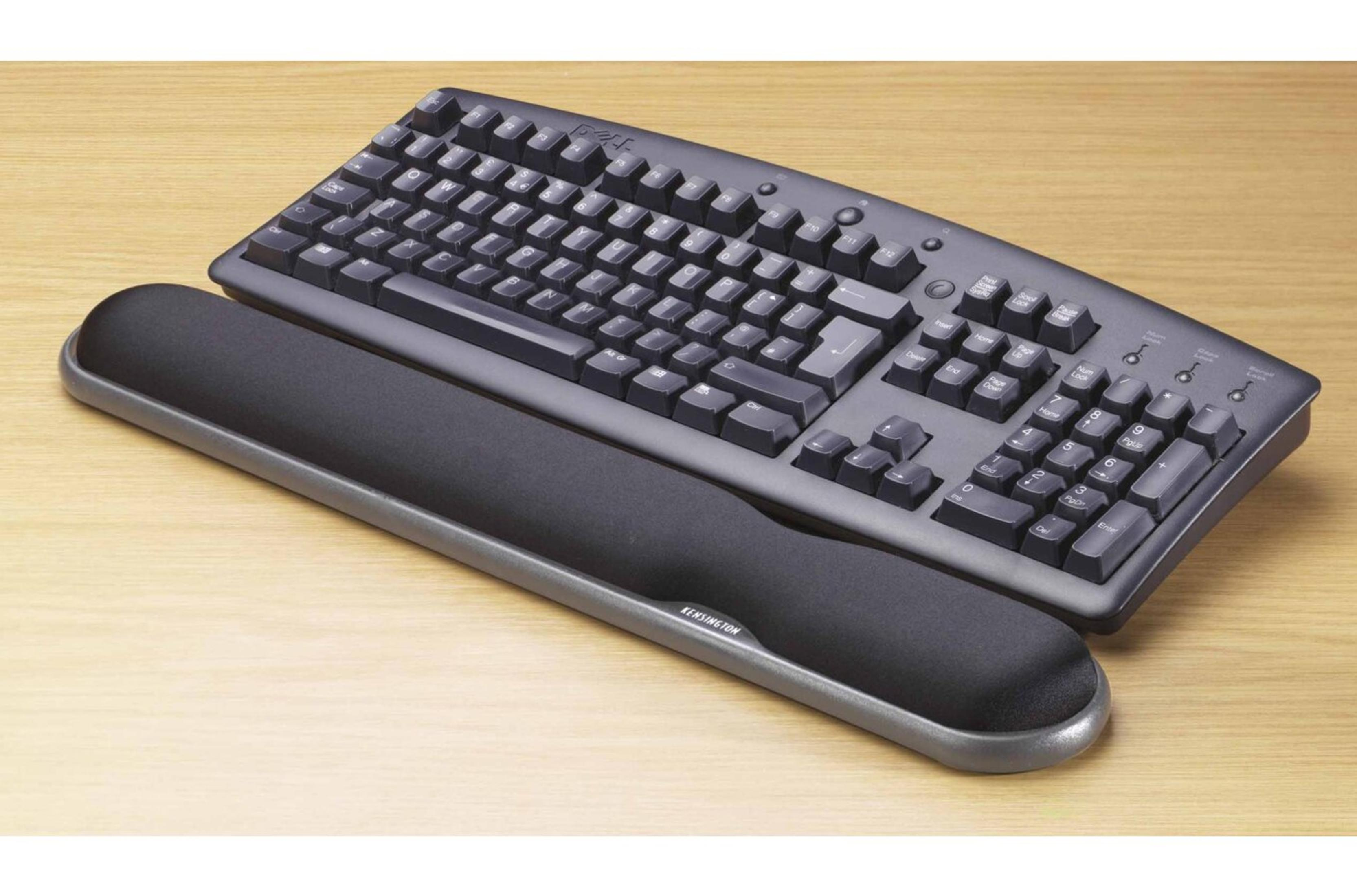 Vista superior de un teclado ergonómico negro y un reposamuñecas negro sobre madera.
