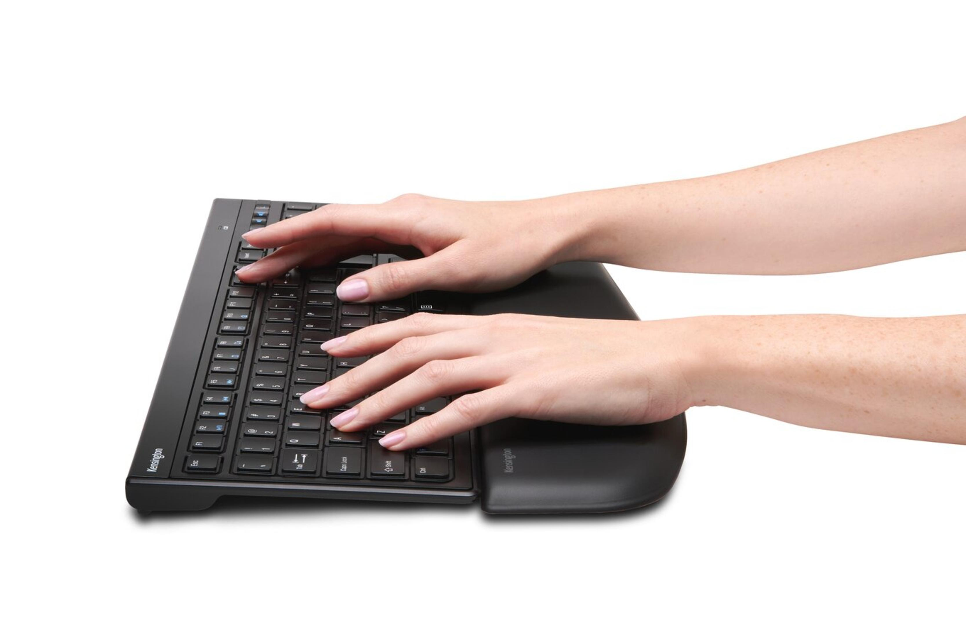 Personne tapant sur un clavier ergonomique noir, mains visibles sur le clavier.