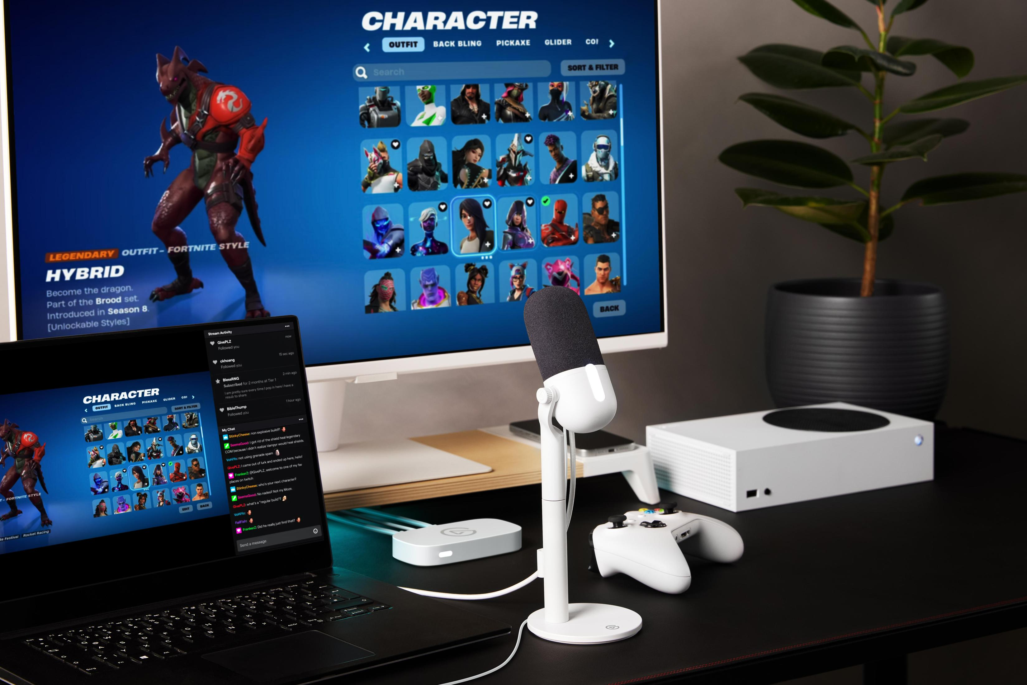 Configuración de juego con monitor mostrando un juego, portátil, micrófono y mando.
