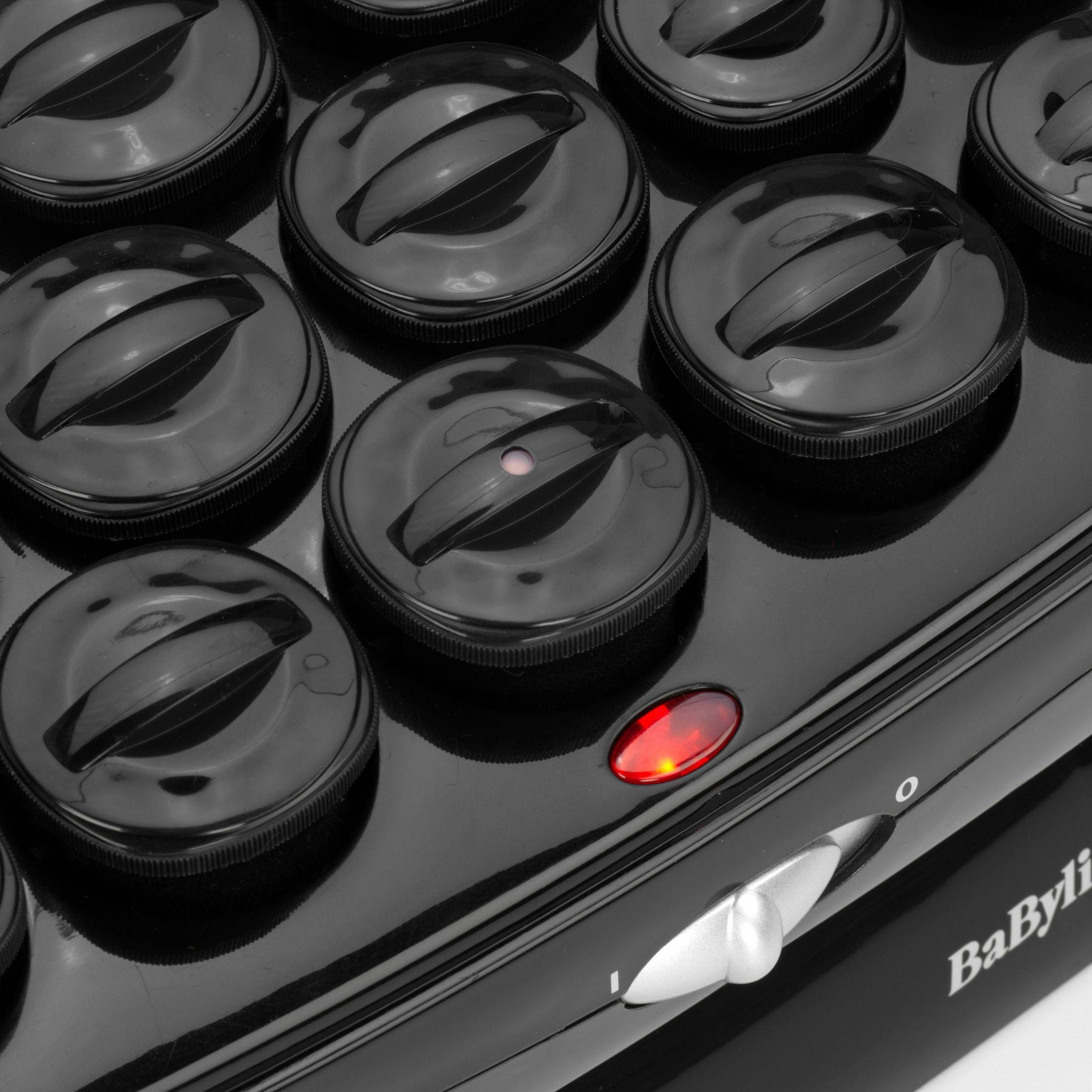 Czarne wałki do włosów ułożone na czarnej powierzchni. Jeden wałek ma czerwone światło, wskazujące, że jest włączony.