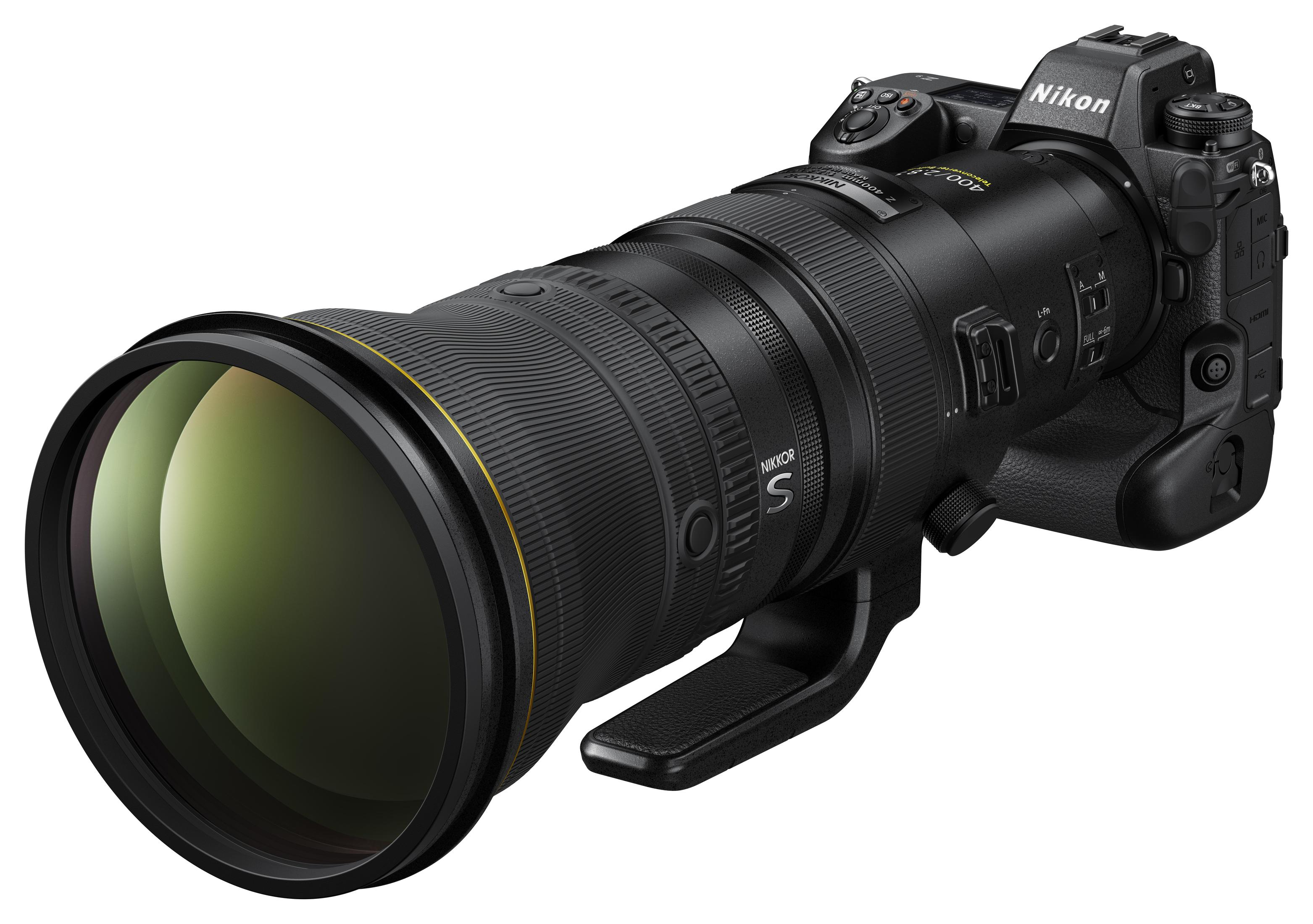 Eine schwarze Nikon-Kamera mit großem Objektiv, vor weißem Hintergrund.