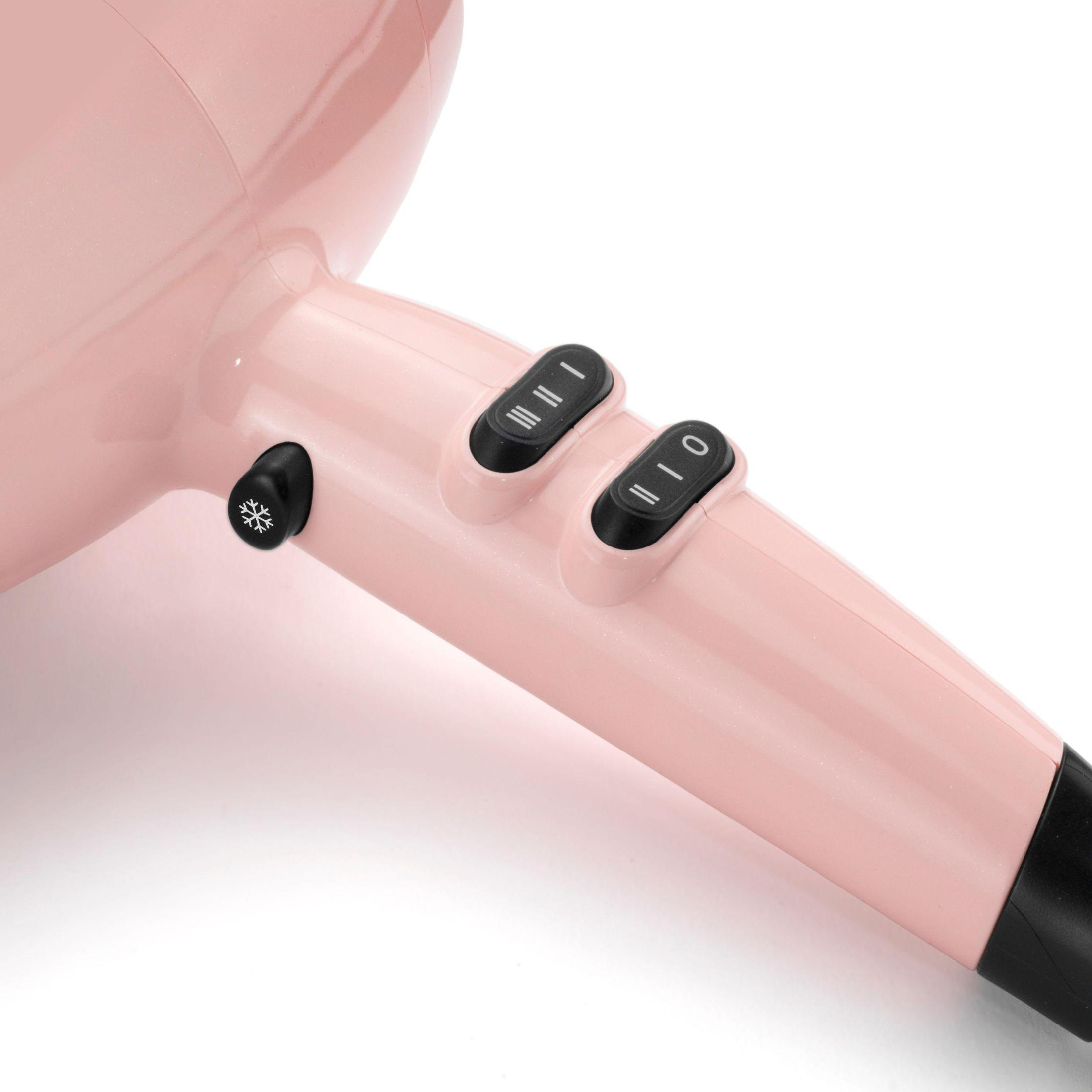 Zbliżenie na różową suszarkę do włosów z czarnymi kontrolkami. Są dwa przyciski i symbol płatka śniegu.