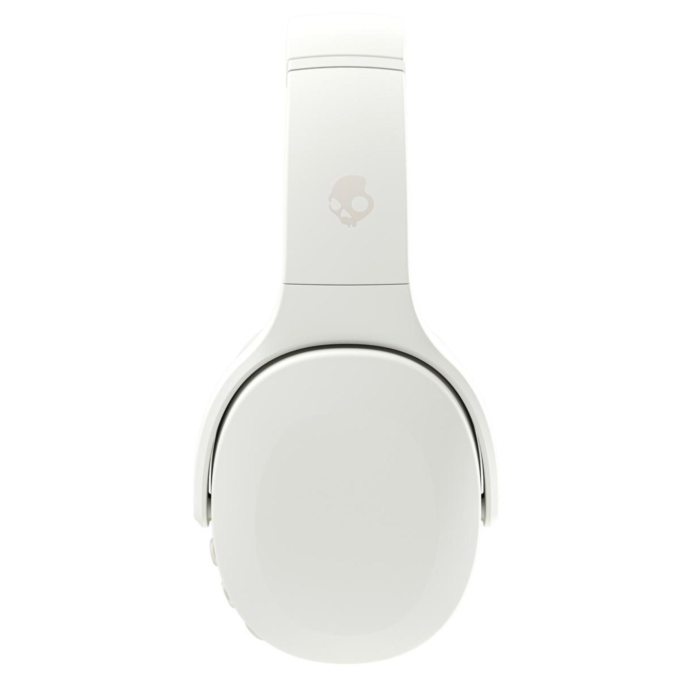Beyaz kulaklık, önden görünüm. Üstte Skullcandy logosu. Beyaz kulaklıklar ve beyaz kafa bandı. Minimalist tasarım.