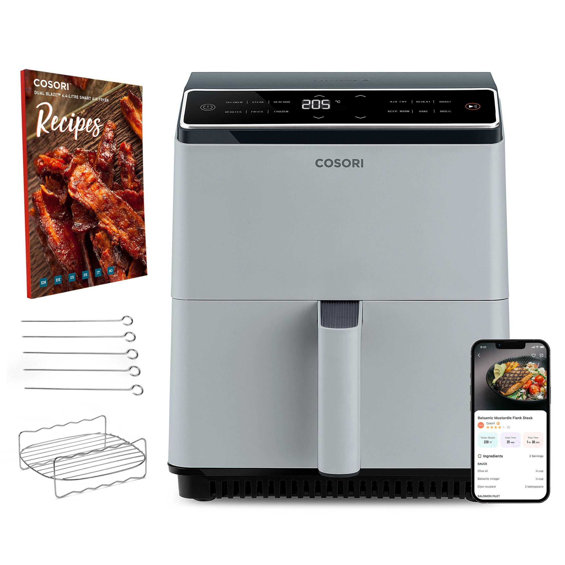 Graue Heißluftfritteuse mit Zubehör und Rezeptbuch. Weißer Hintergrund, Touchscreen-Anzeige.