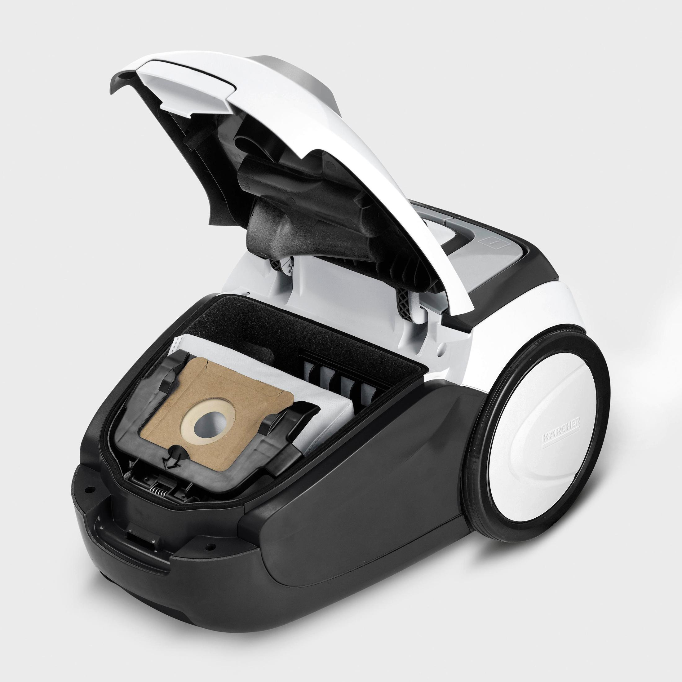 Biało-czarny odkurzacz z otwartą pokrywą, ujawniający brązowy worek filtrujący. Koło jest białe.