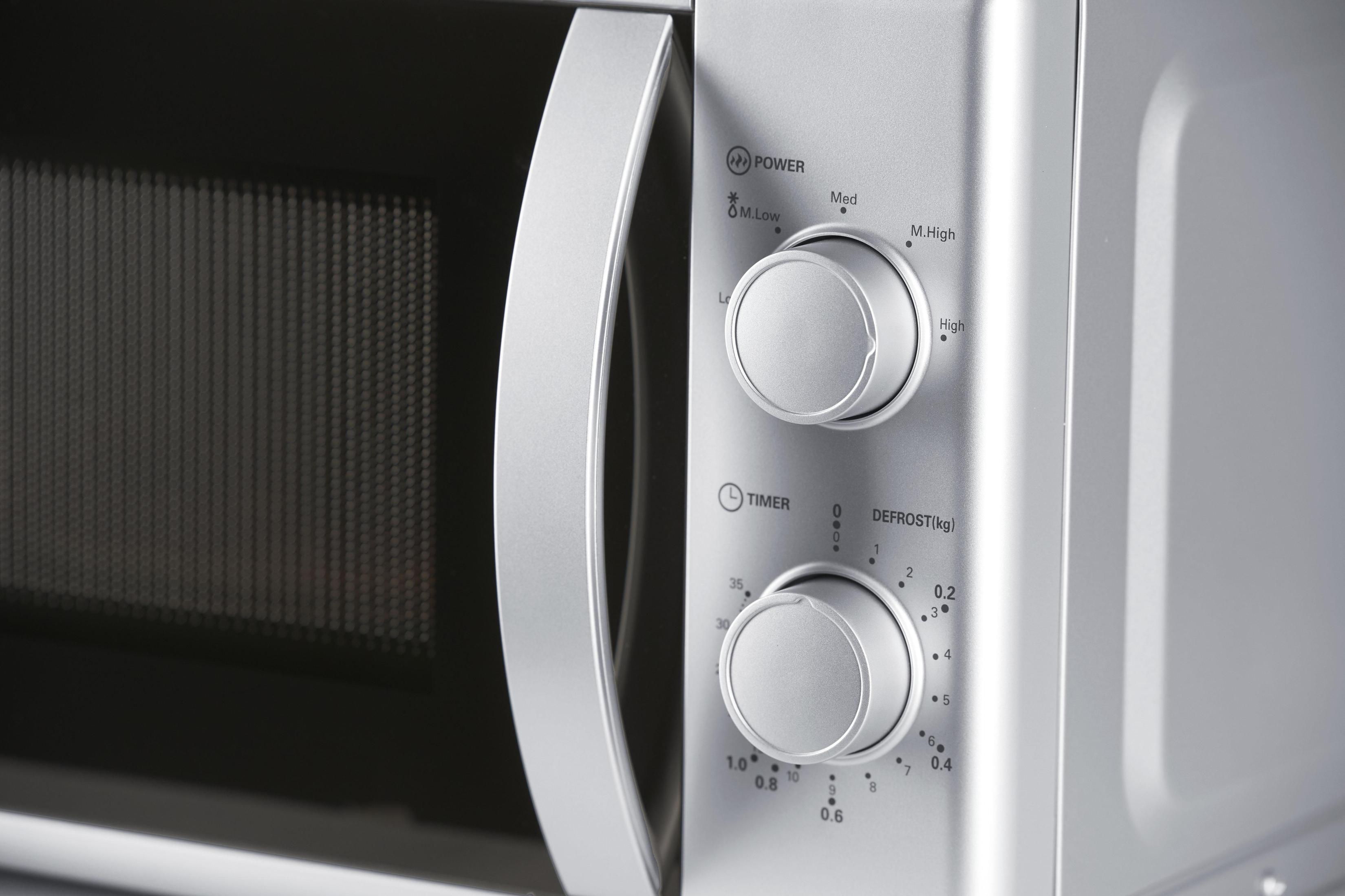 Microwave oven with control panel visible, showing power and timer controls.