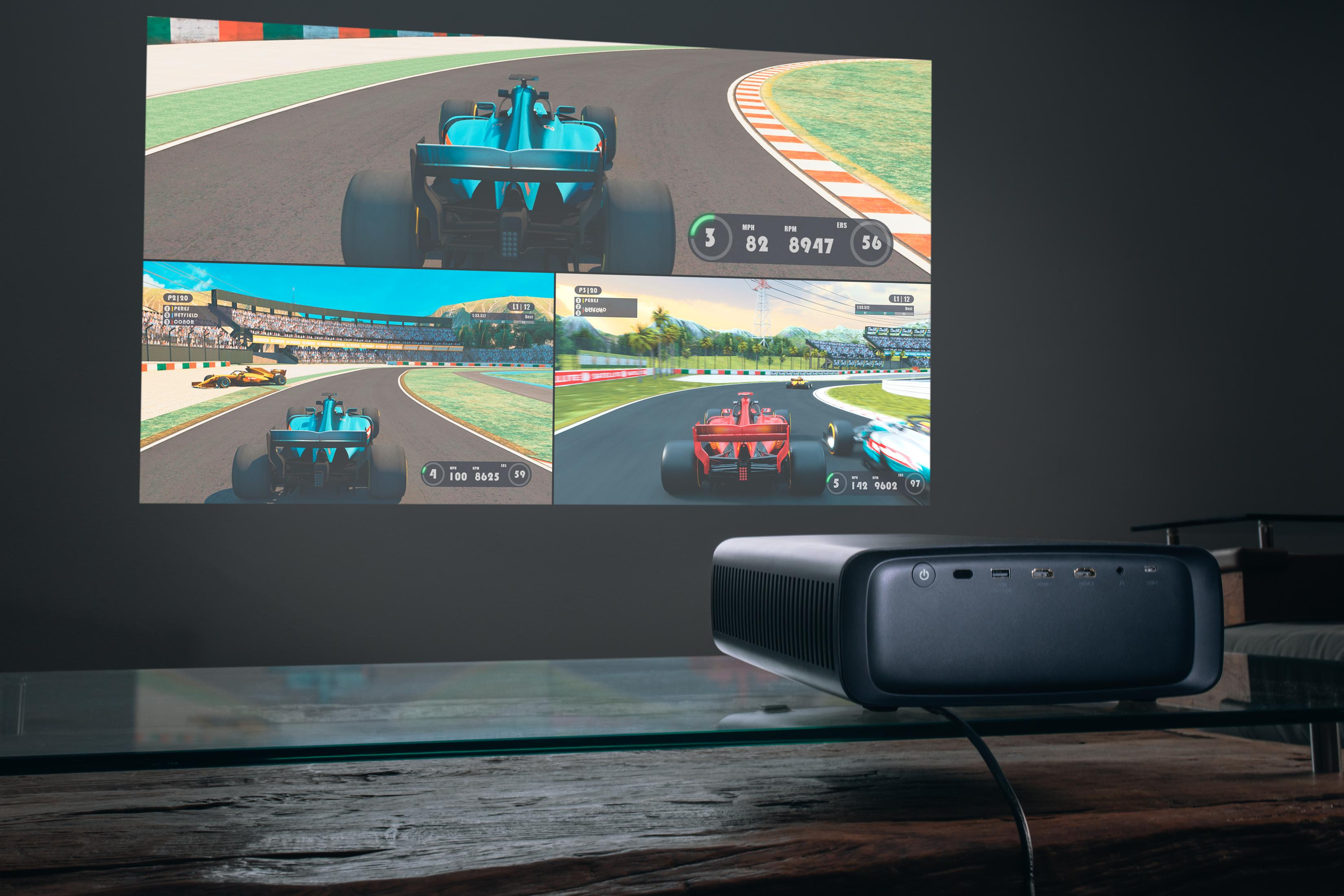 Projektor wyświetlający sceny z gier wyścigowych na ekranie.