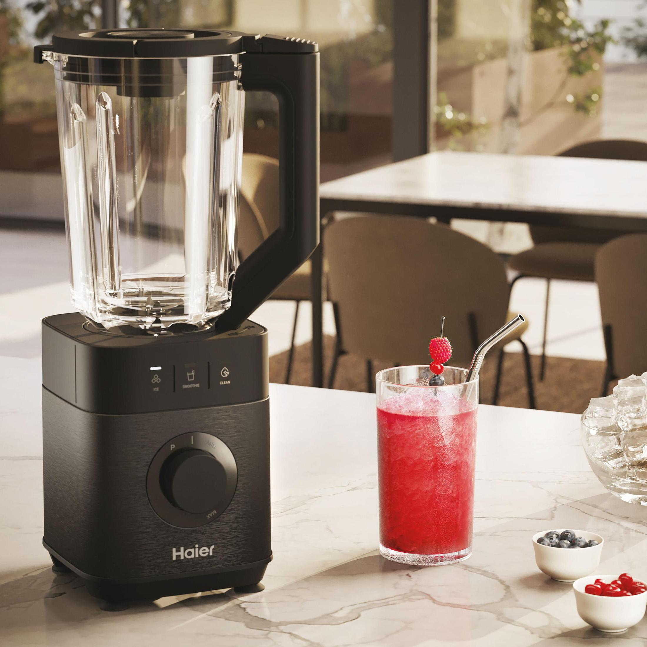 Czarny blender ze szklaną karafką, szklanką czerwonego smoothie i składnikami.