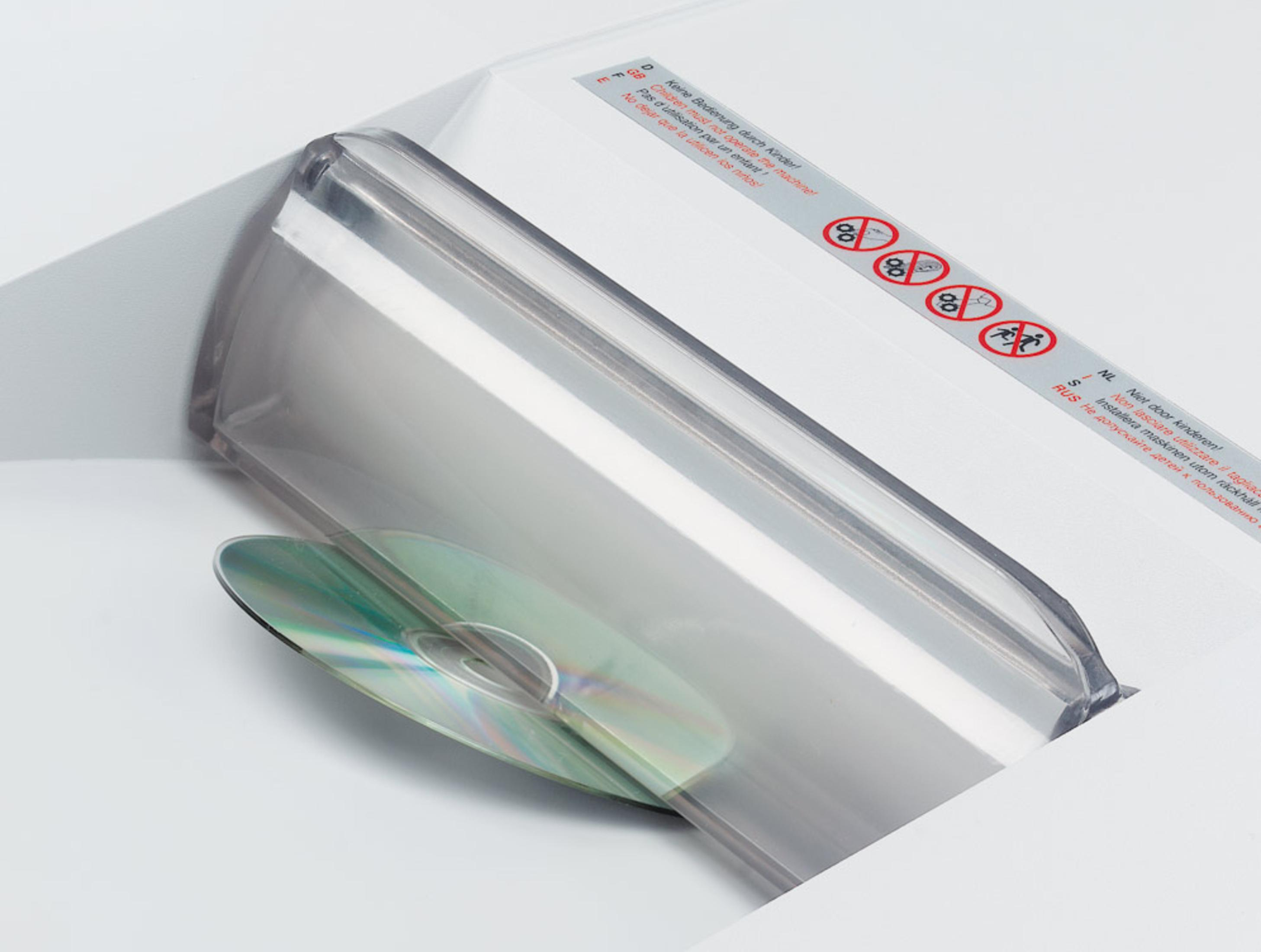 CD in einem weißen Aktenvernichter. Sicherheitshinweise sind sichtbar.