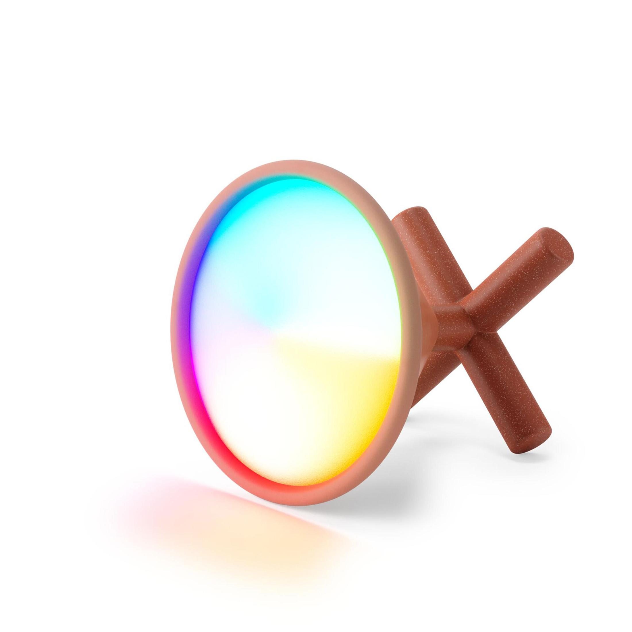 Un oggetto rotondo e luminoso su una base marrone a forma di croce, che mostra i colori dell'arcobaleno.