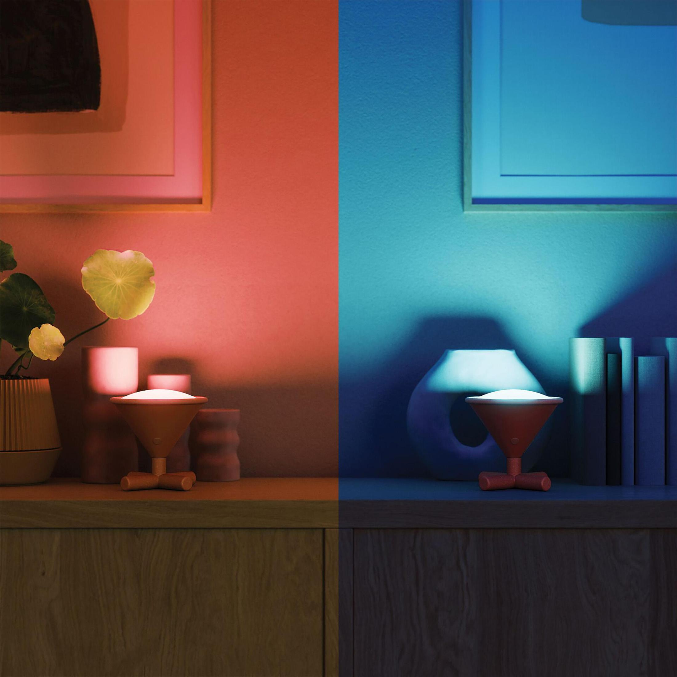 Un tavolo con due schemi di colore, uno rosso, l'altro blu. Una lampada e decorazioni sono sul tavolo.