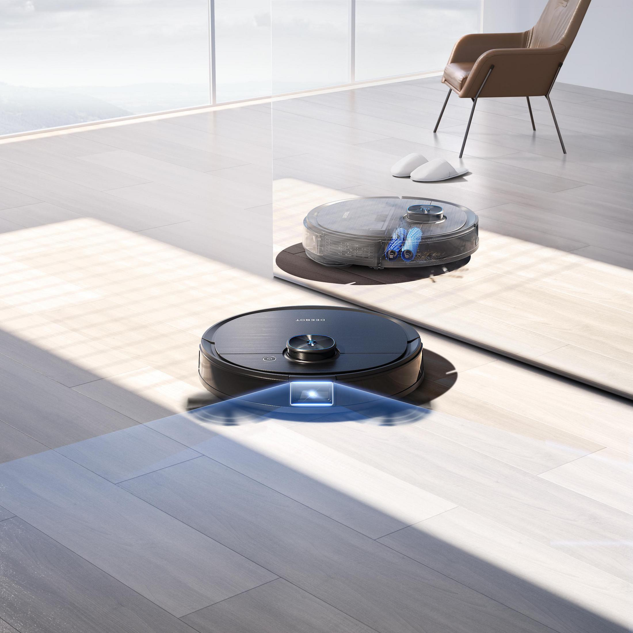 Zwei Roboter-Staubsauger auf einem Holzboden. Einer reinigt, der andere ist angedockt. Licht scheint.