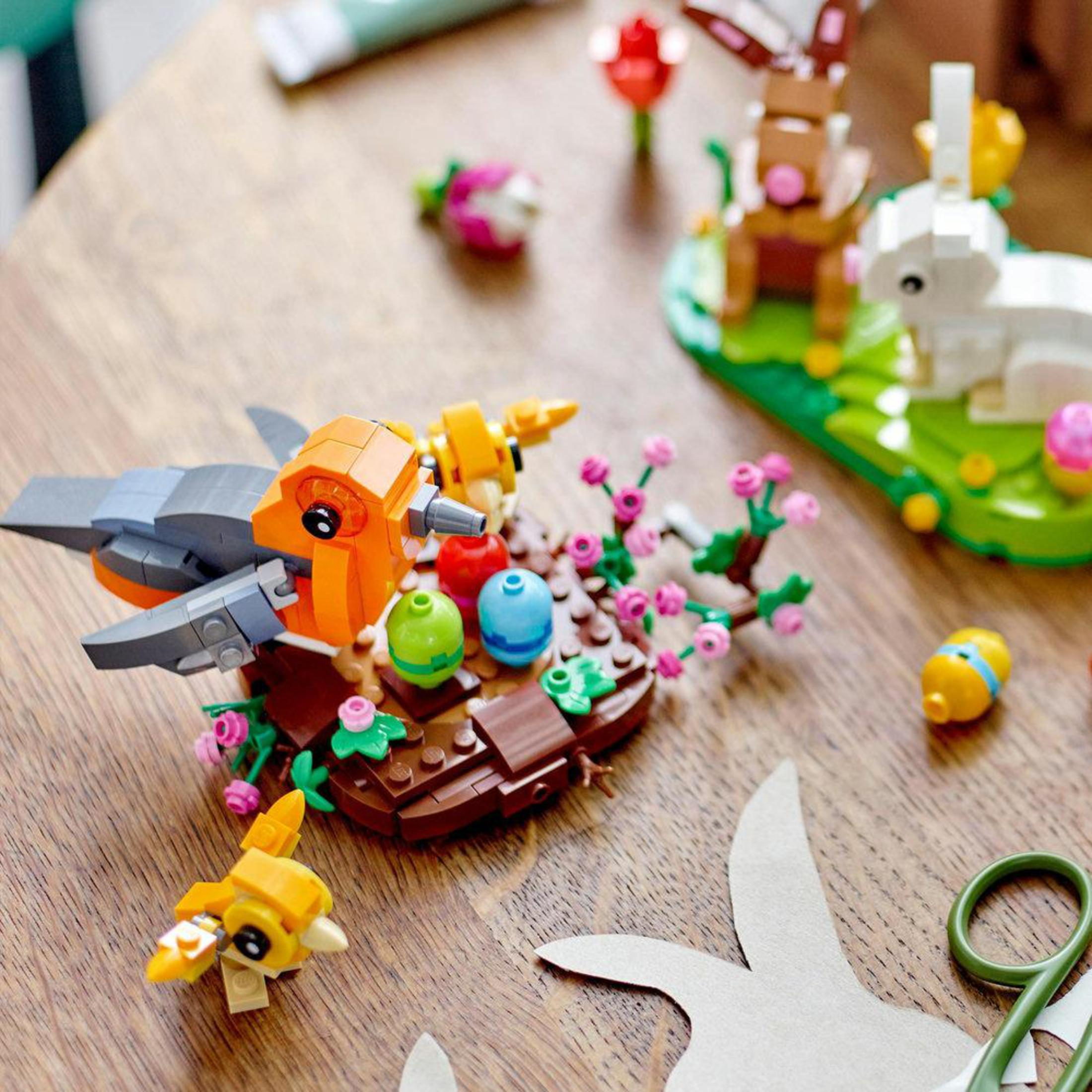 LEGO Ostern-Szene. Vögel, Eier und Hasen. Hintergrund aus Holztisch. Bunt und verspielt.