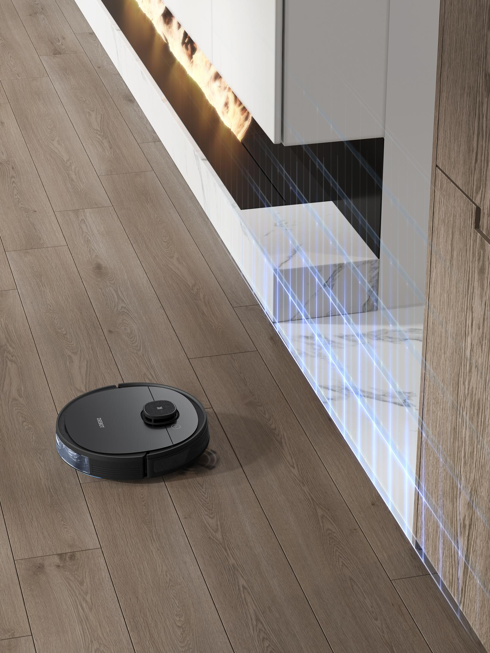 Roboter-Staubsauger auf Holzboden, in der Nähe eines Kamins und Schrankes.