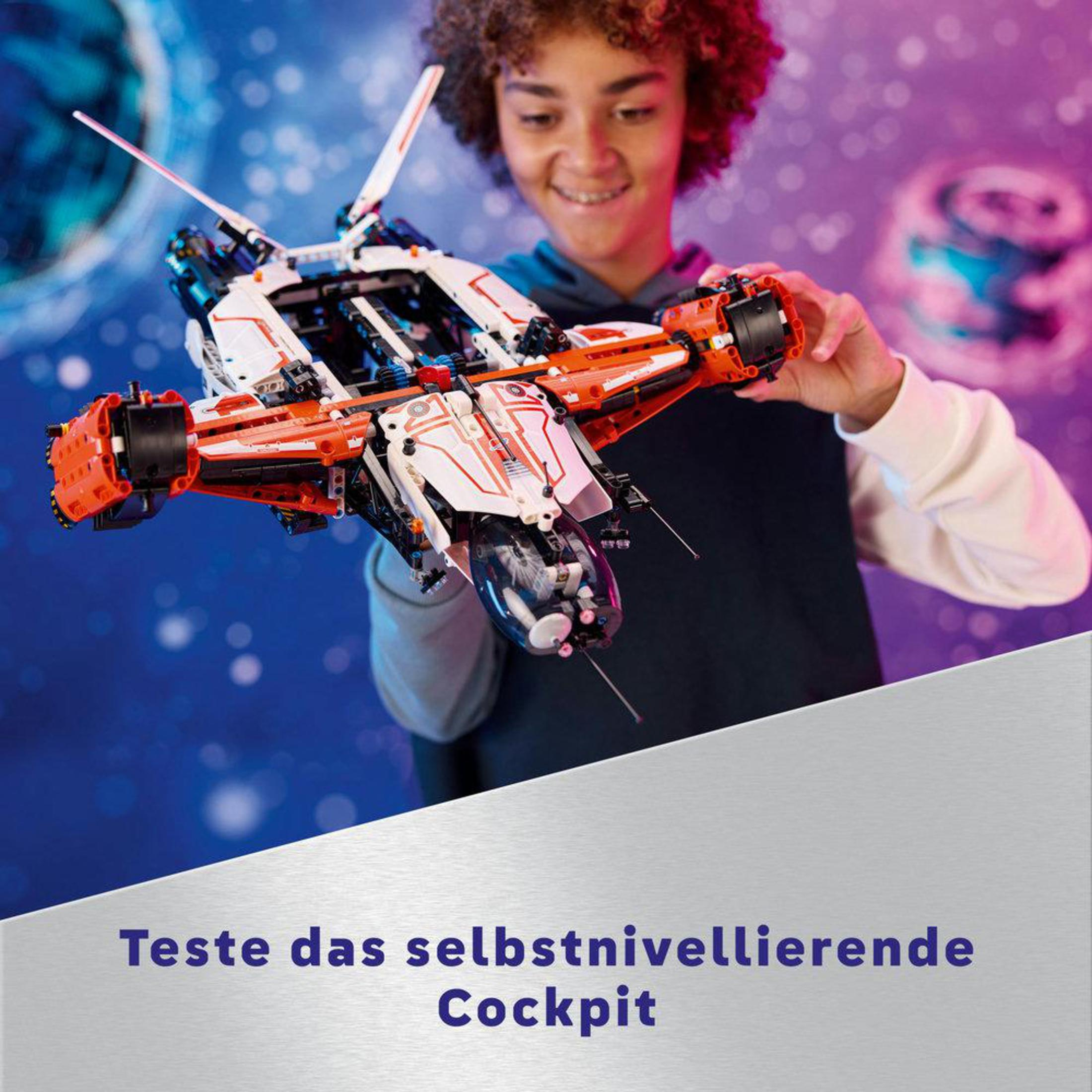 Lego uzay gemisi olan çocuk. Uzay gemisi beyaz ve turuncudur. Mavi zemin.