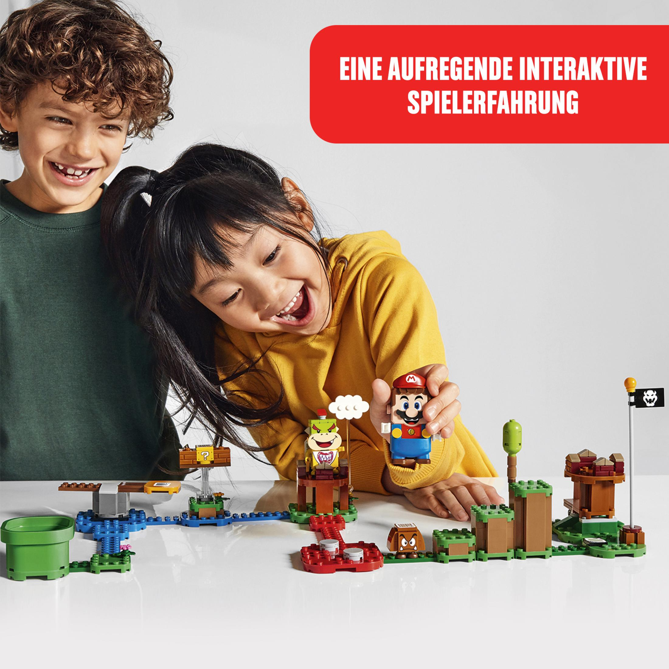 Kinder spielen mit Lego Super Mario Set, Mario Figur wird von einem Kind gehalten.