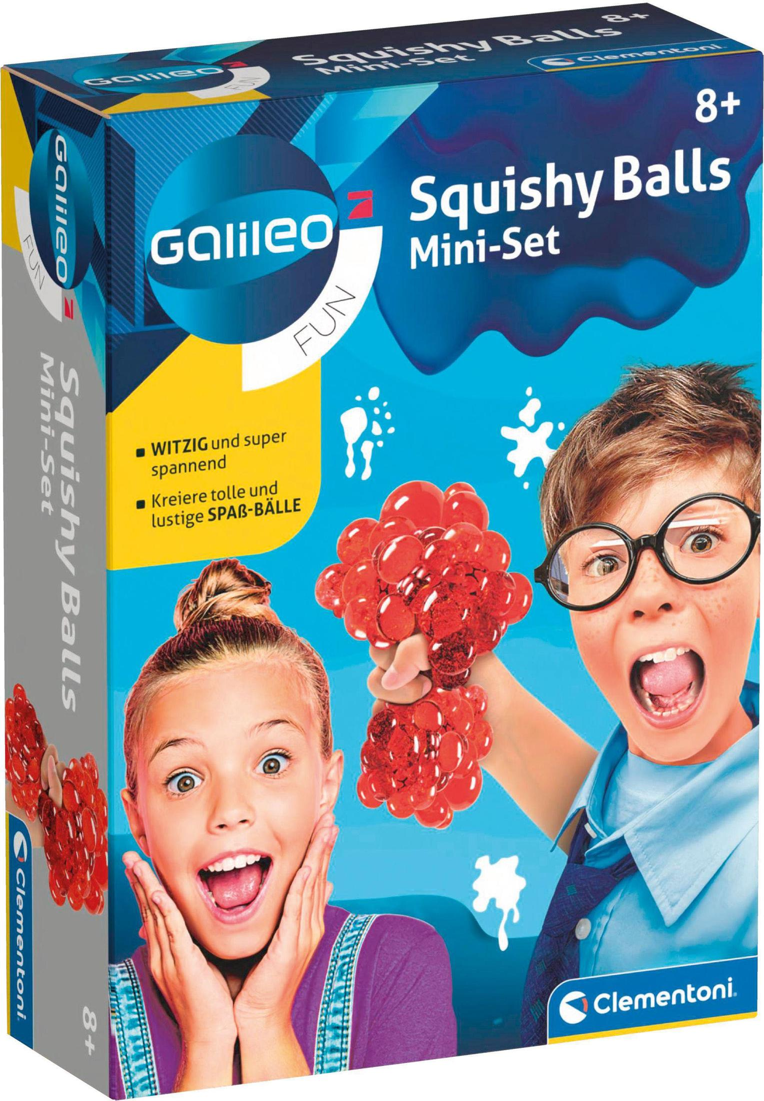 Schachtel mit Galileo Squishy Balls. Junge mit Brille und Mädchen sind aufgeregt. Rote Bälle werden gehalten. Blauer Hintergrund. Marke Clementoni.