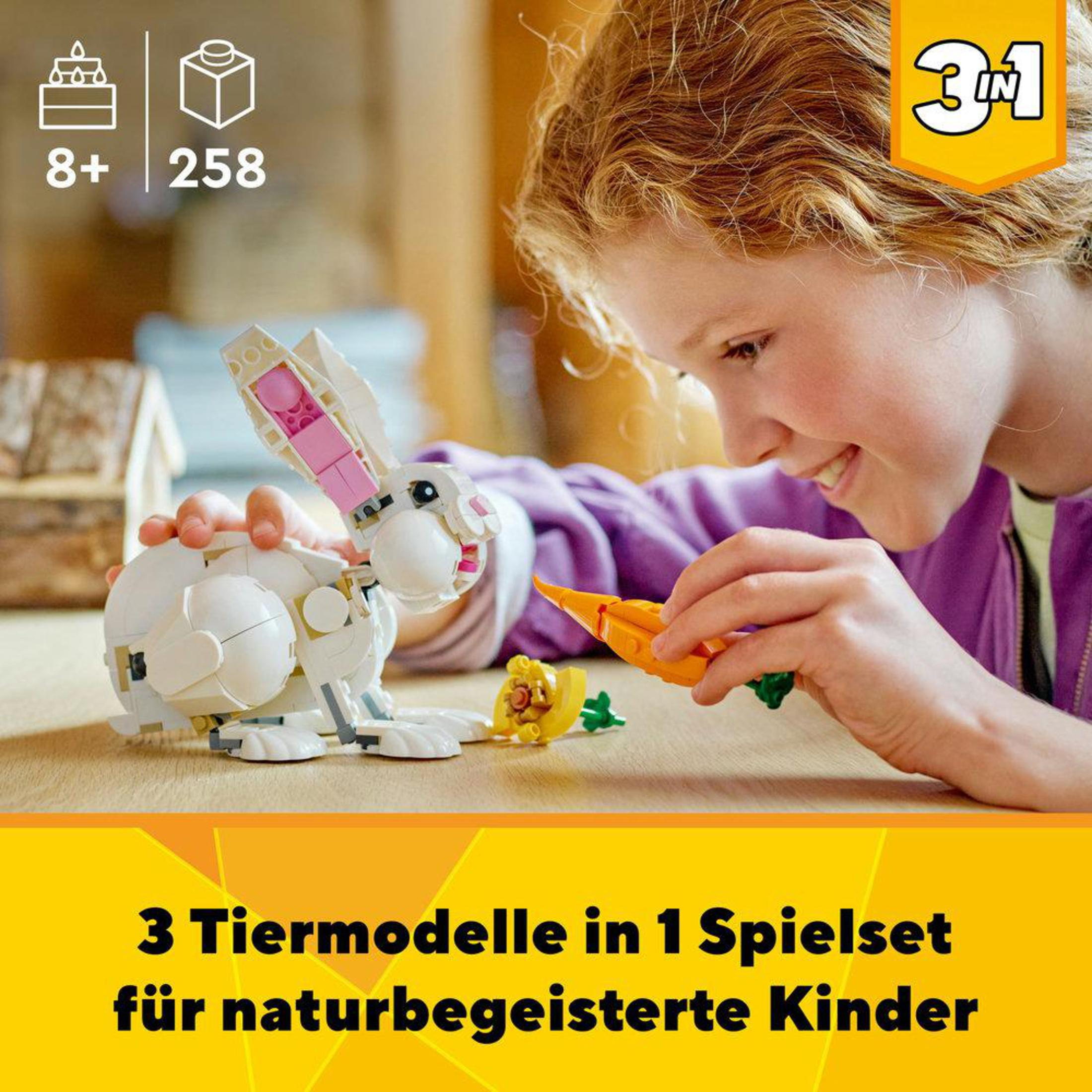 Ein Mädchen spielt mit einem weißen Lego-Kaninchen-Spielzeug und hält eine Karotte.