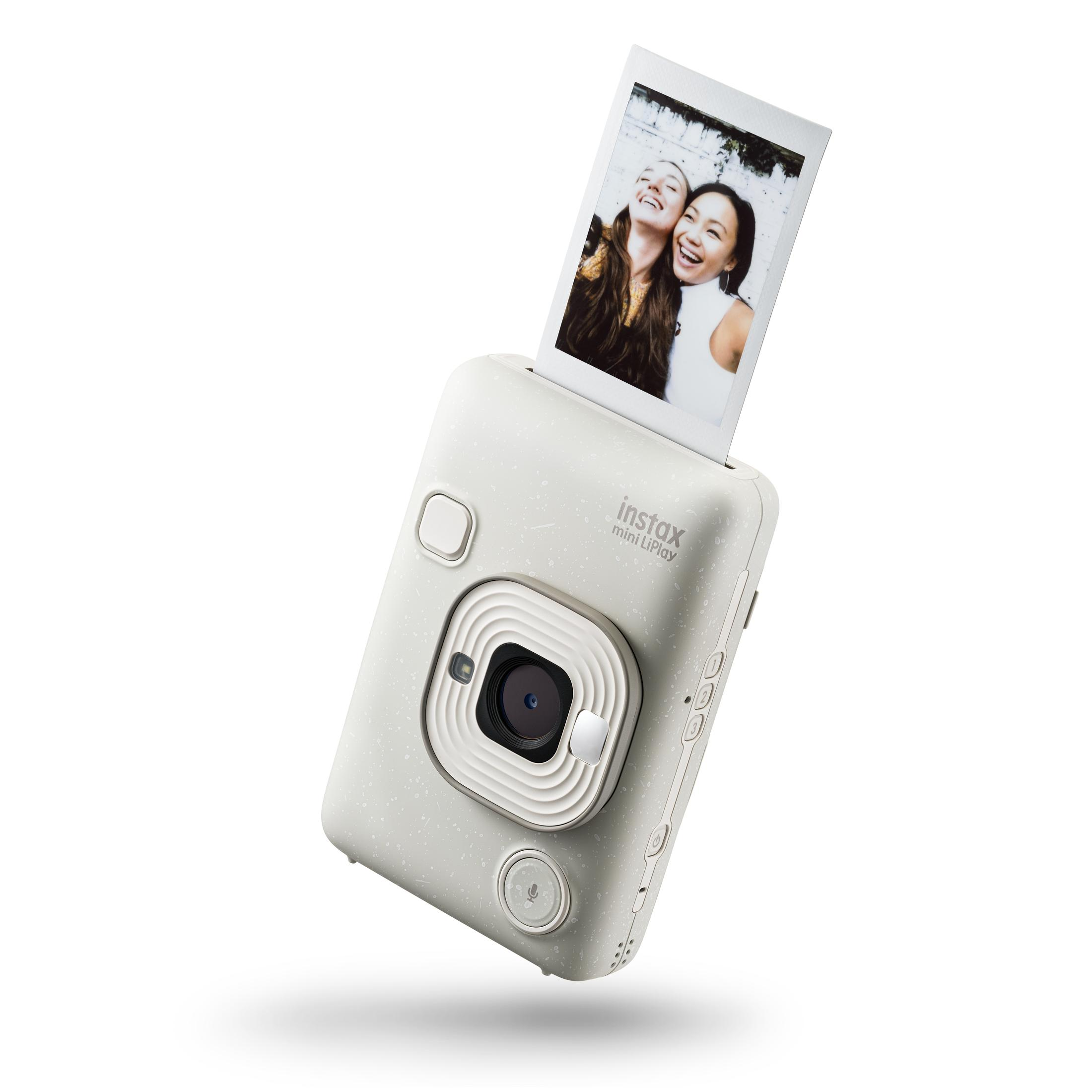 Biały aparat Instax Mini LiPlay, ze zdjęciem dwóch kobiet, na białym tle.