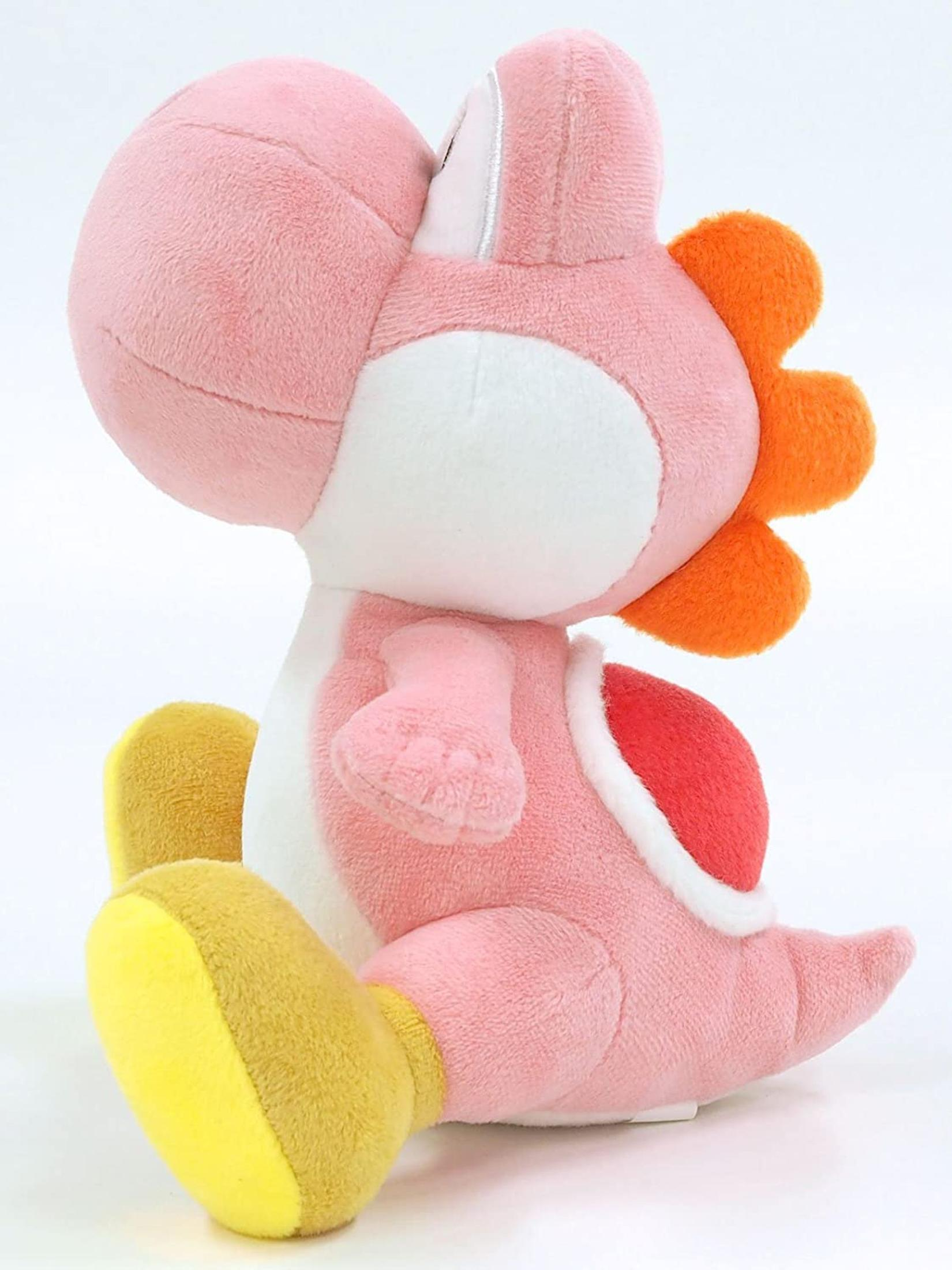 Peluche Yoshi rose, assis avec des accents orange et blancs.