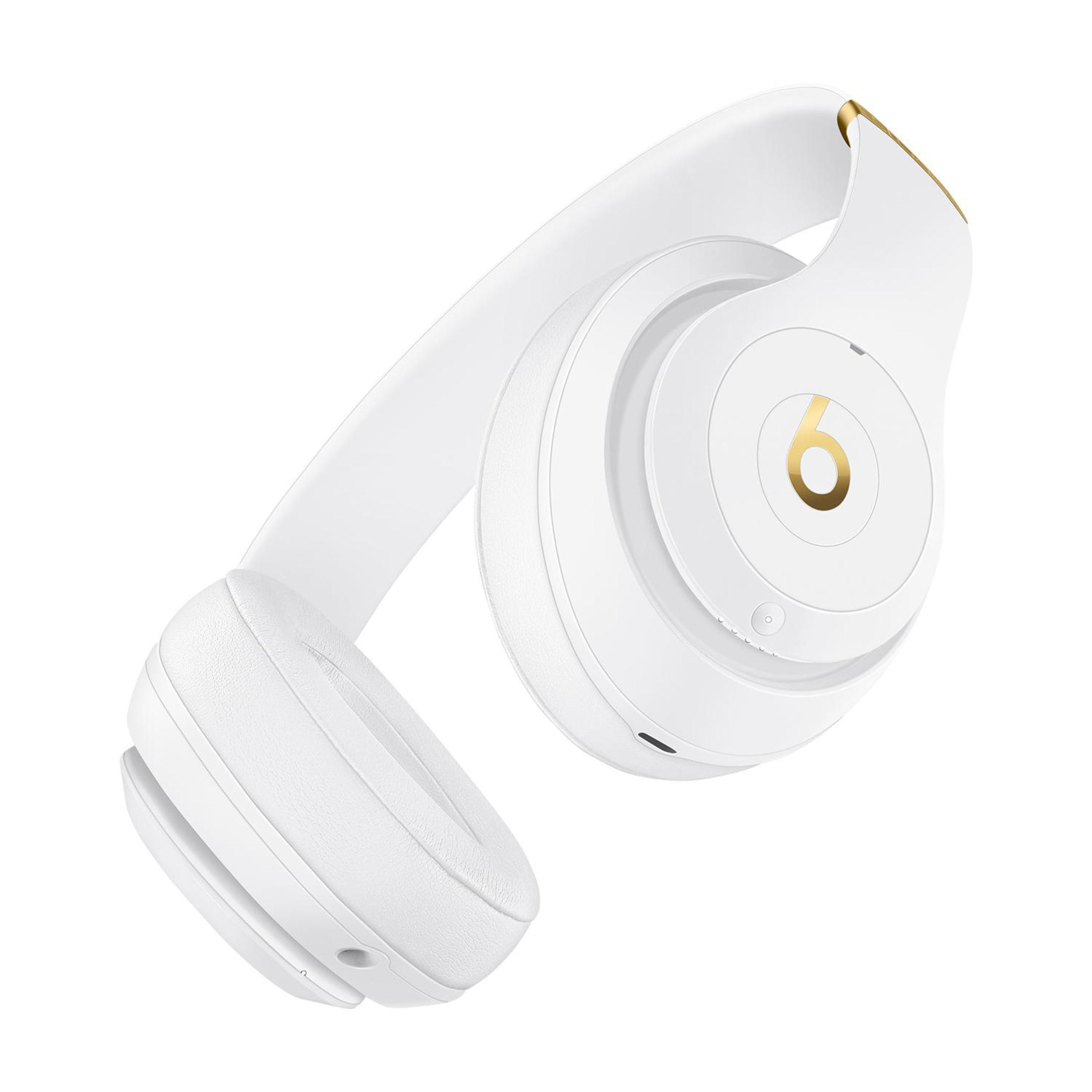 Auriculares Beats blancos con detalles dorados, en ángulo. Los auriculares están sobre un fondo blanco.