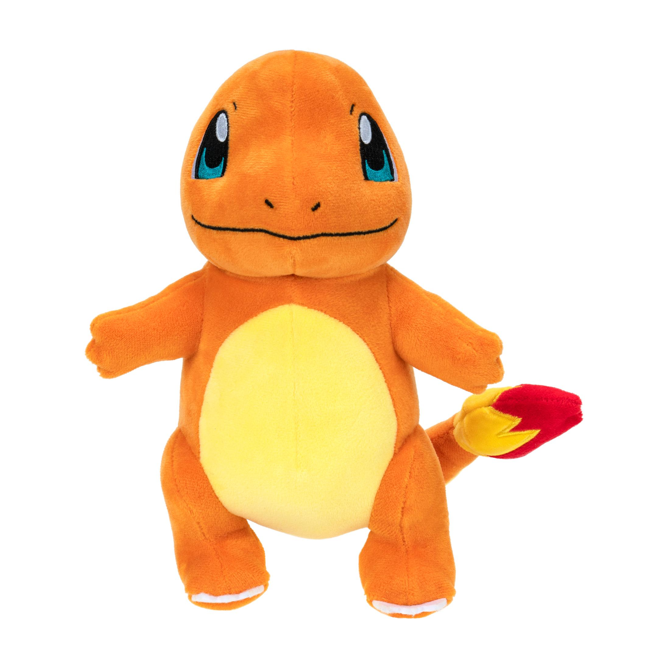 Orangenes Charmander-Plüschtier auf weißem Hintergrund. Es steht, mit gelbem Bauch und Flammenschwanz.
