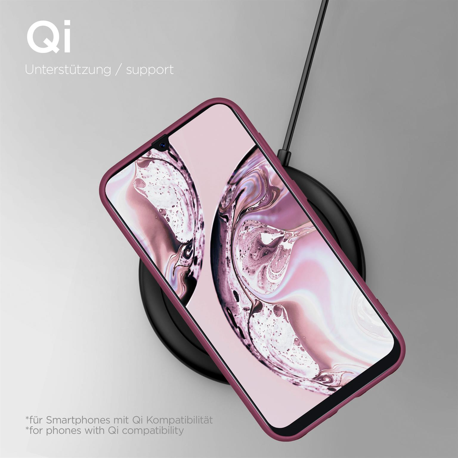 Ein Telefon in einer weinroten Hülle liegt auf einem kabellosen Ladegerät. Ein schwarzes Kabel erstreckt sich nach oben.