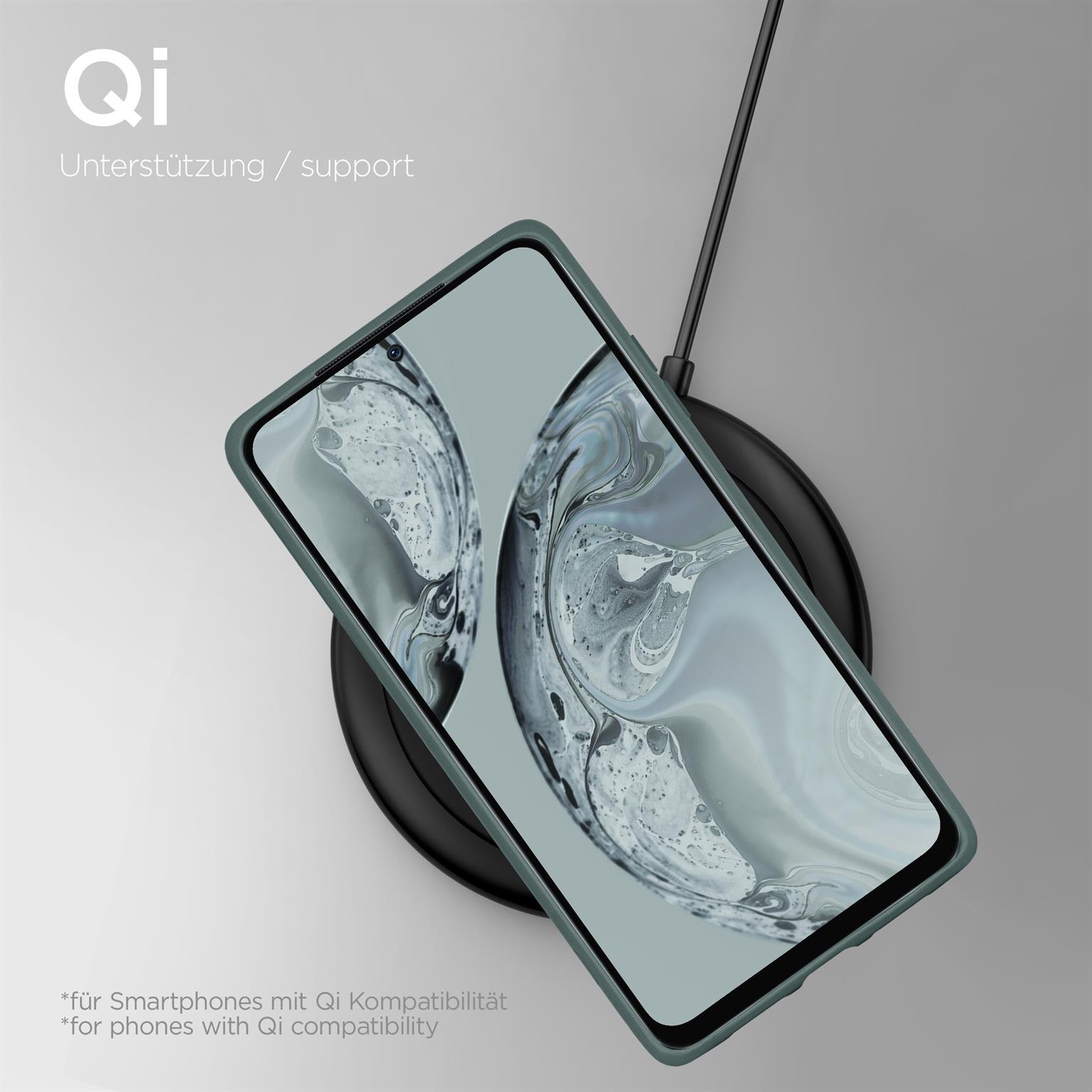 Ein Telefon in einer grünen Hülle auf einem kabellosen Ladegerät mit dem Wort Qi oben.