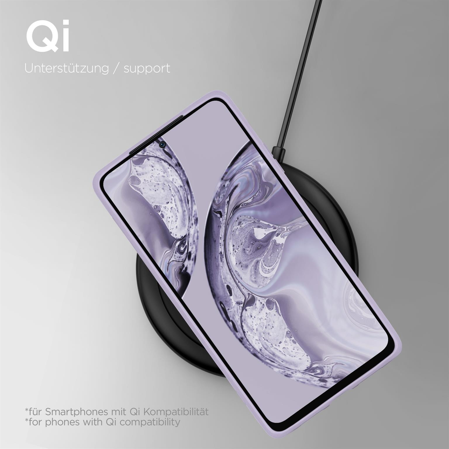 Ein Telefon in einer lila Hülle lädt auf einem kabellosen Ladegerät, auf grauem Hintergrund.