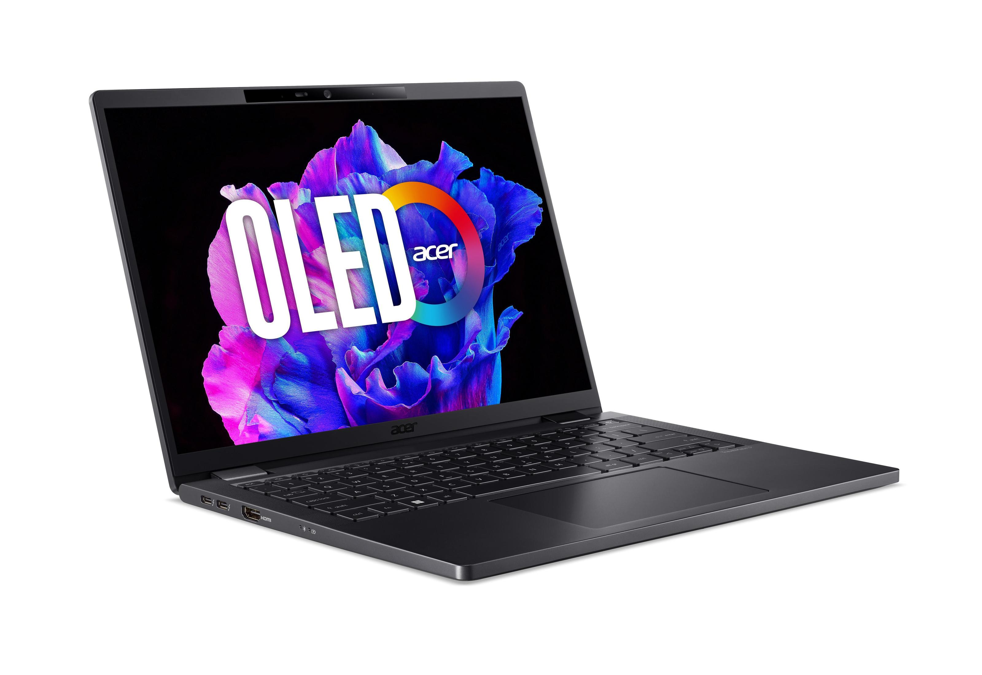 Laptop con 'OLED' sullo schermo, aperto su una superficie bianca. Ha una tastiera nera e un telaio argentato.