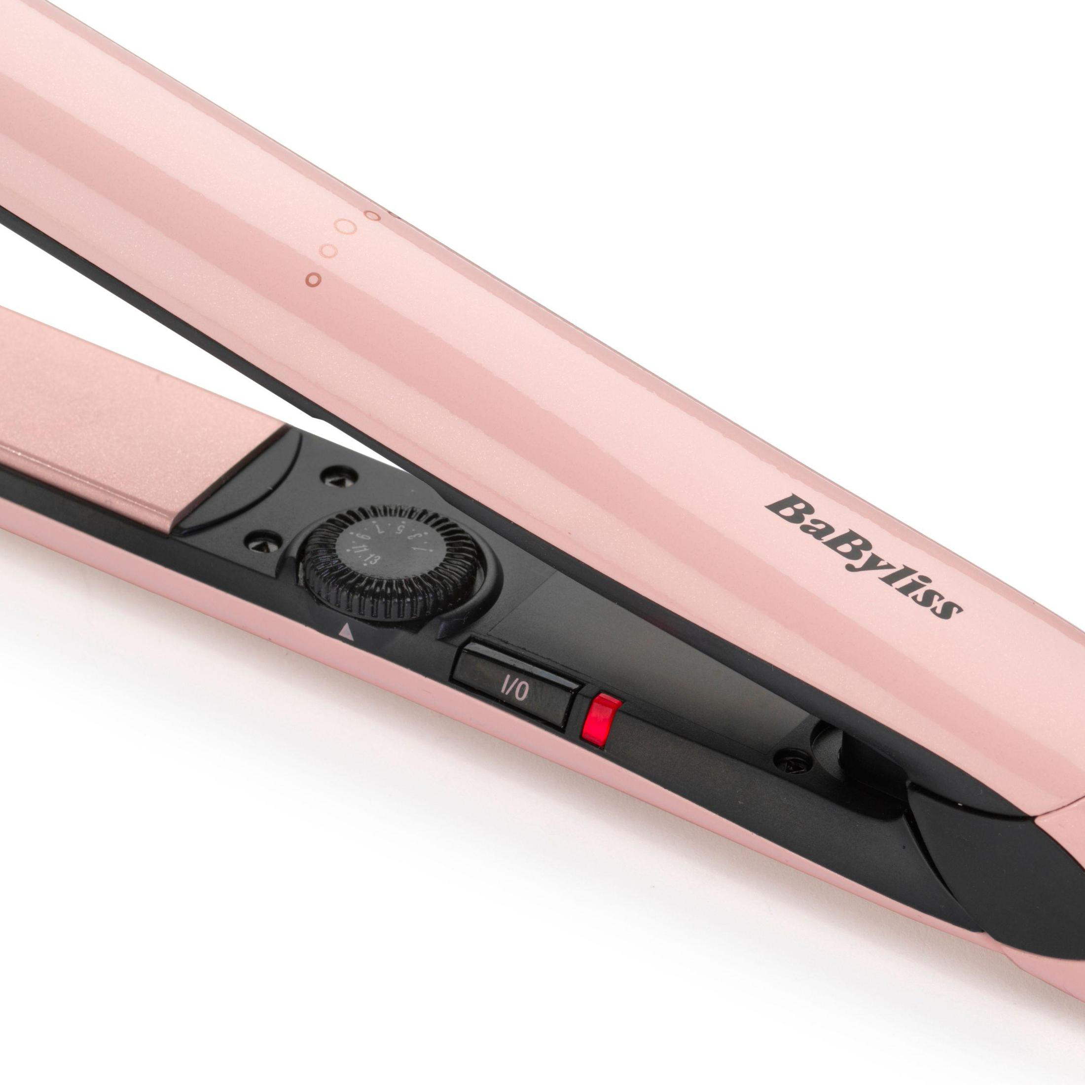 Pembe bir BaByliss saç düzleştirici, yakın çekim. Beyaz zemin.