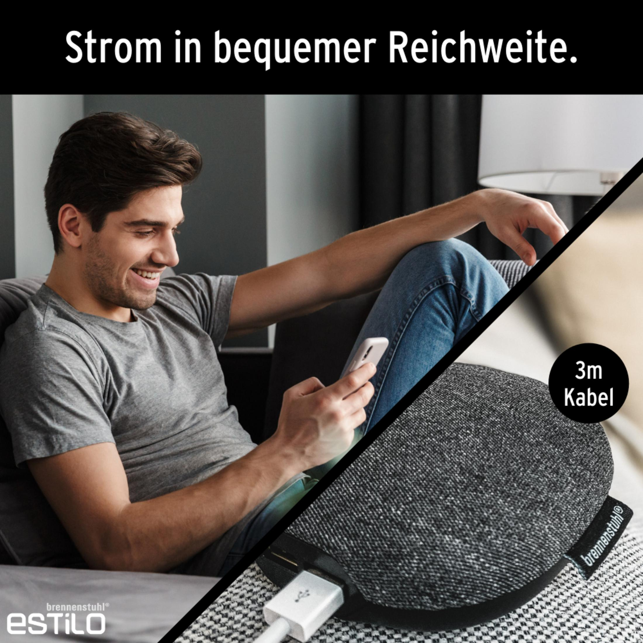 Mann sitzt auf einem Sofa und benutzt ein Telefon, eine Powerbank in der Nähe.